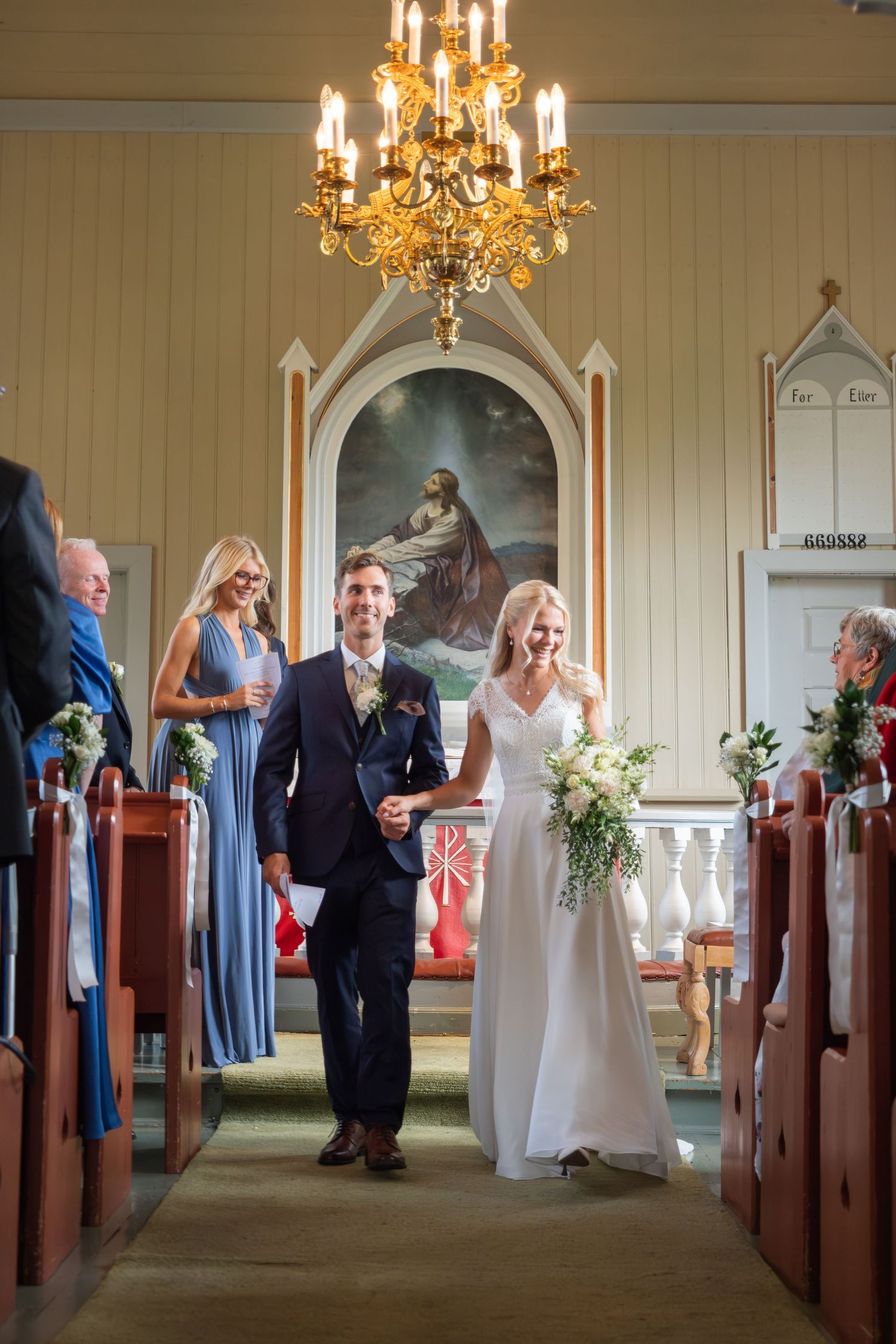 Smiling newlyweds walking down the church aisle after their wedding ceremony.