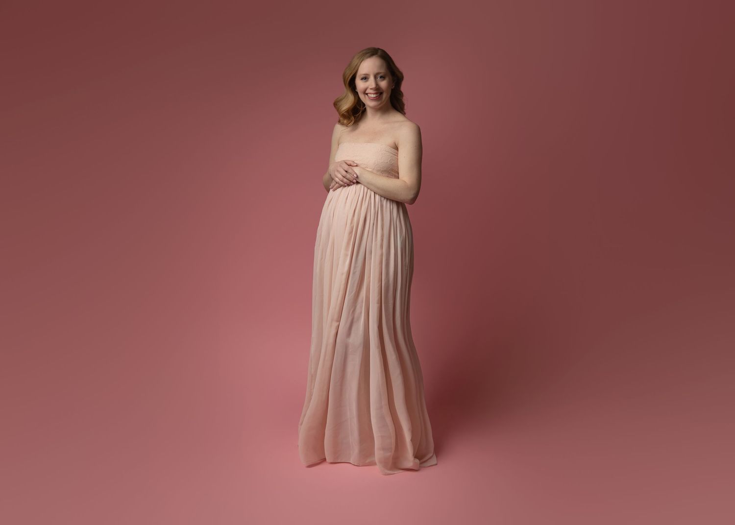 A dusty pink maternity dress photographed in multiple angles against a rose-colored studio backdrop.
