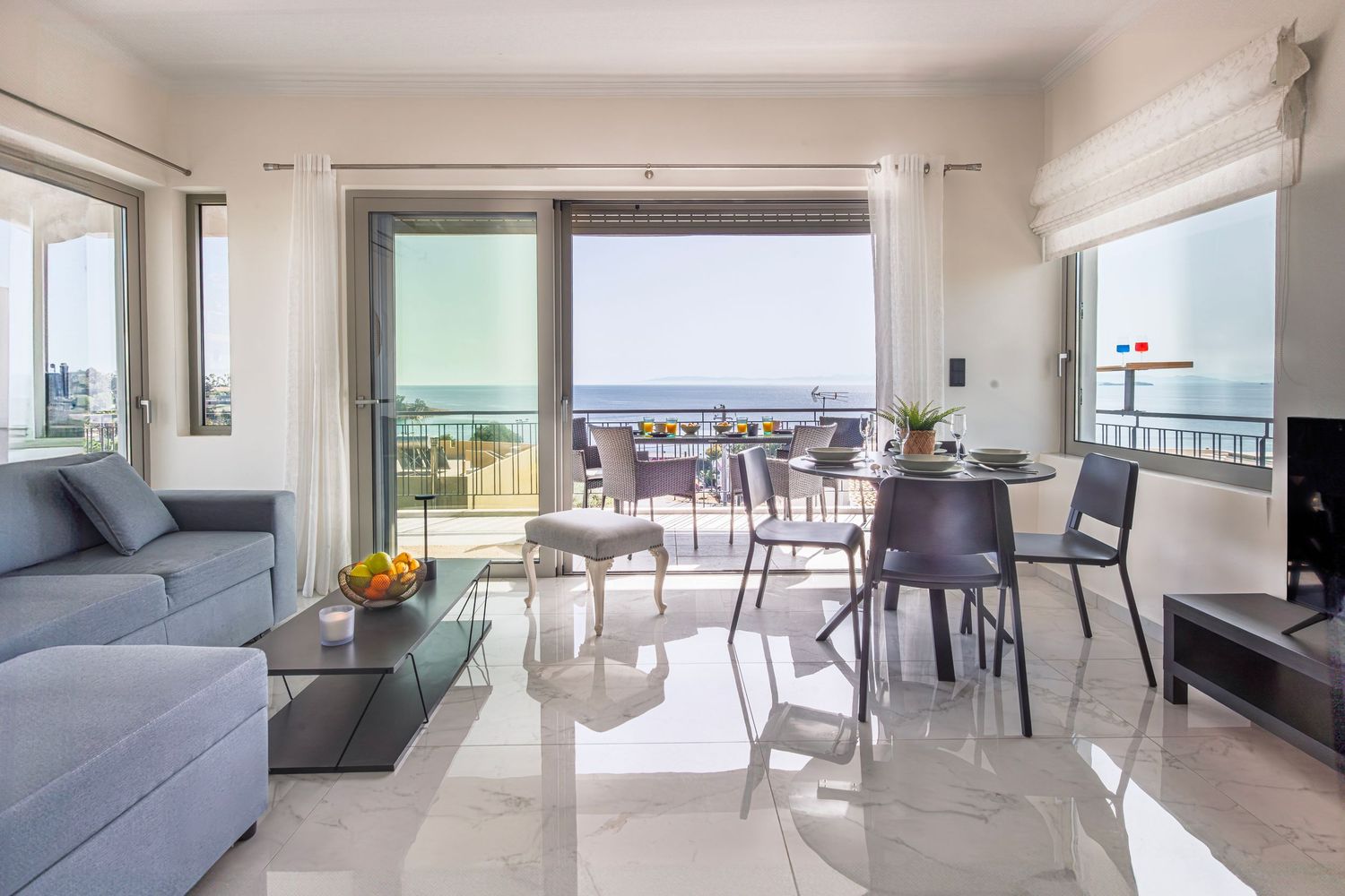 Bright contemporary apartment living room with ocean view balcony and modern furnishings.