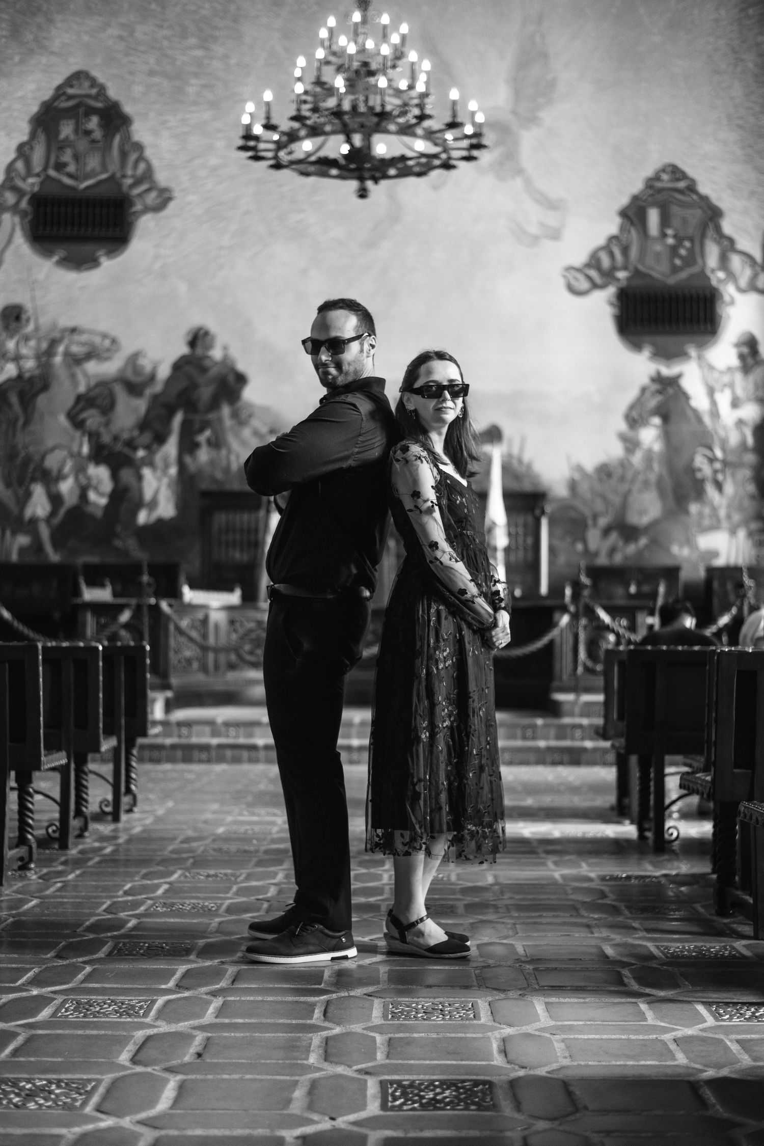 Natural editorial documentary Santa Barbara courthouse wedding moment of a couple standing back‑to‑back in an ornate hall in black and white
