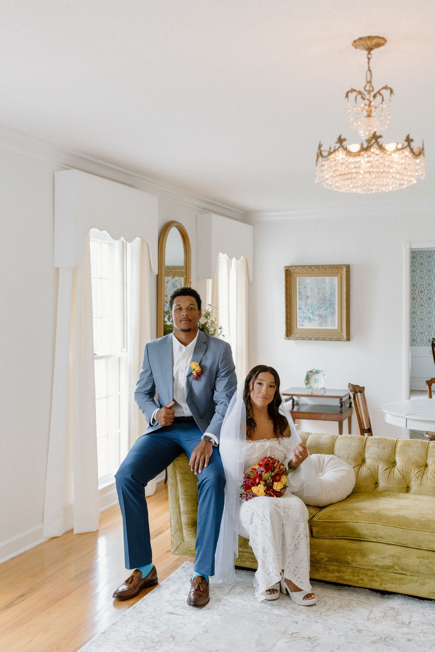 Elegant interior photoshoot featuring a luxurious living room with crystal chandelier and vintage gold-framed decor.