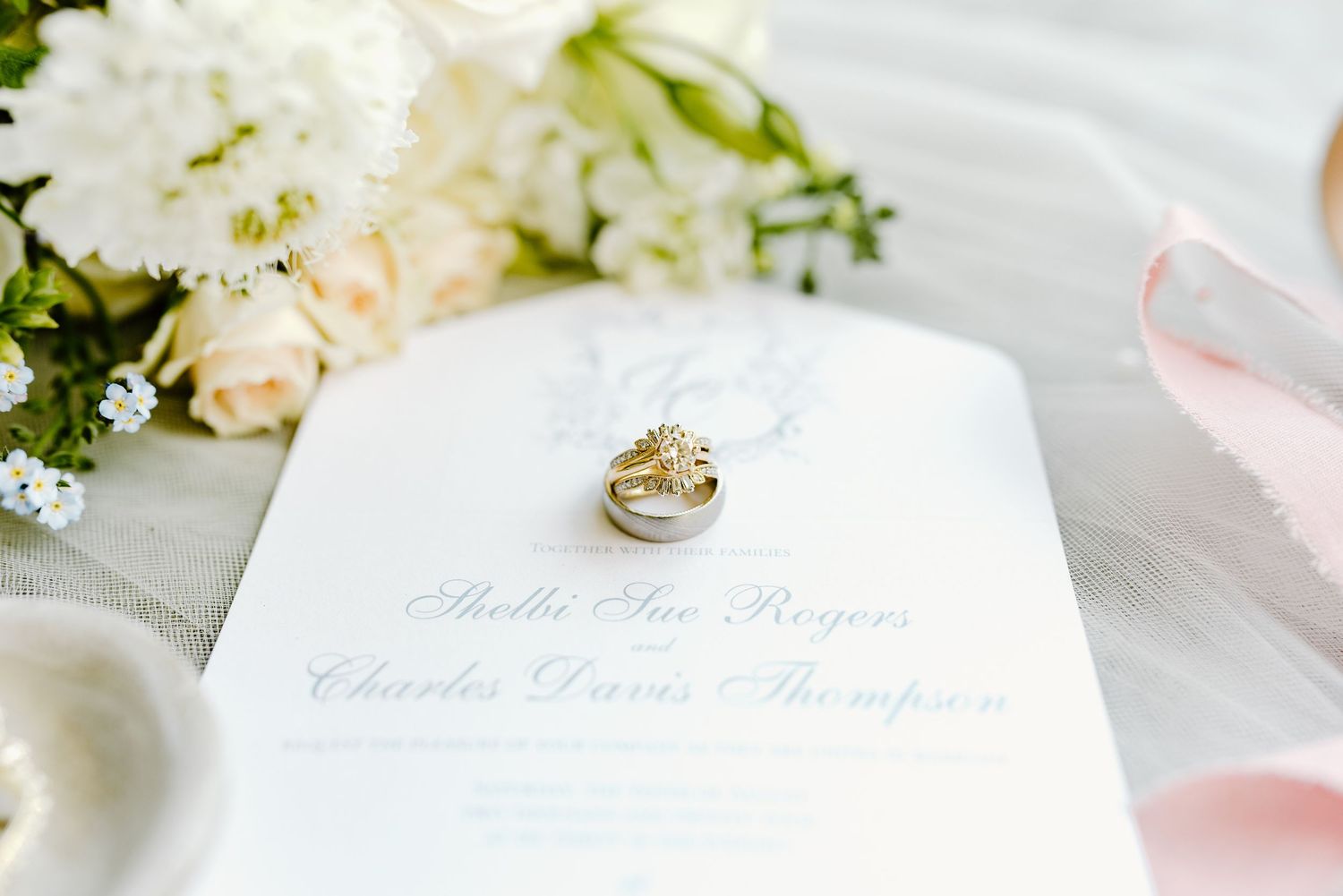 Elegant wedding invitation suite with calligraphy and soft pink accents.