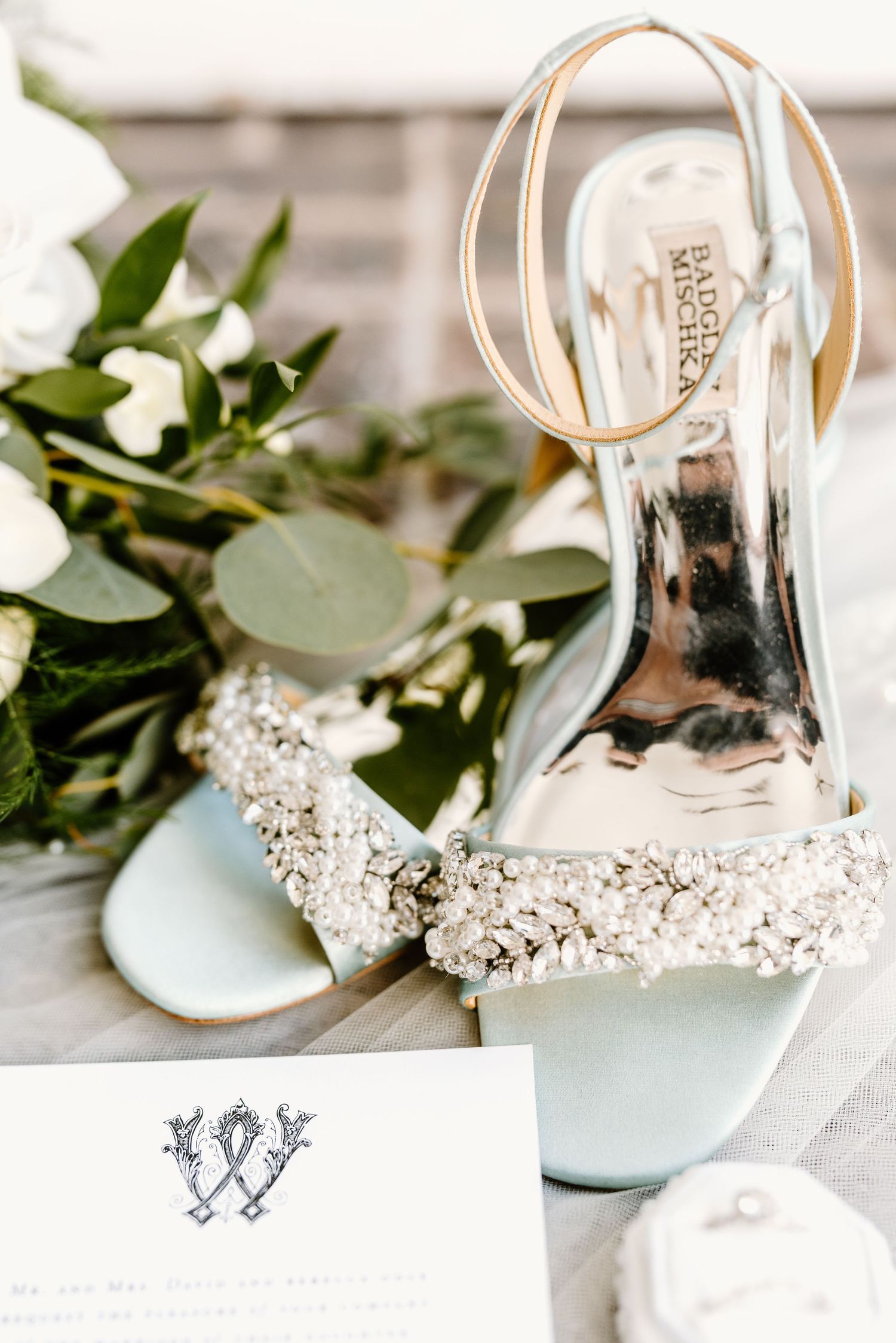 Wedding accessories including sparkly shoes and floral decorations arranged artistically.