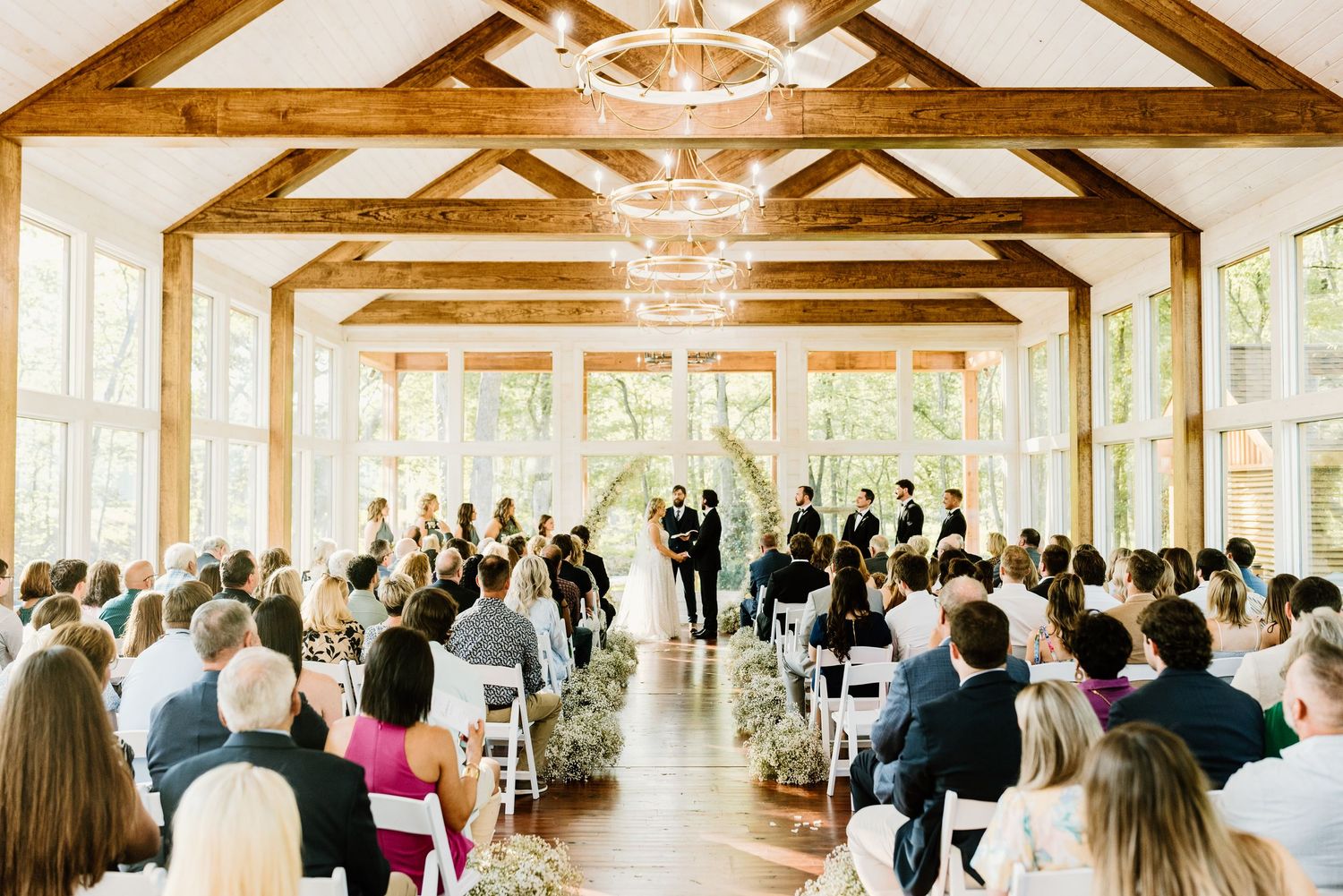 Interior view of a wedding ceremony venue with exposed wooden beams and rows of seating.