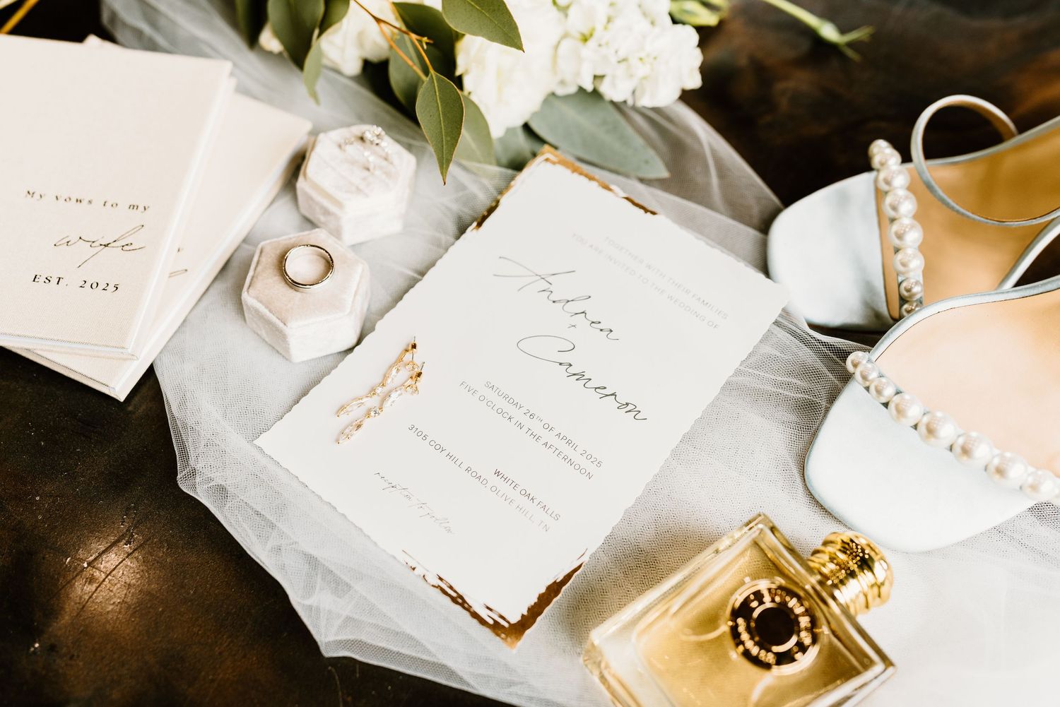 Wedding stationery and rings styled with elegant calligraphy and floral elements.