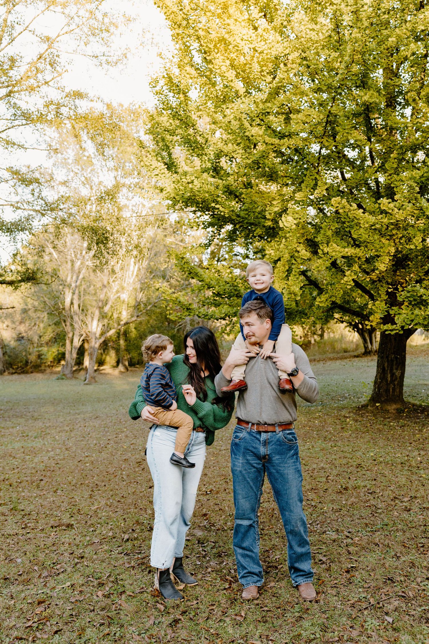 Playful family moment captured in an autumn park setting.