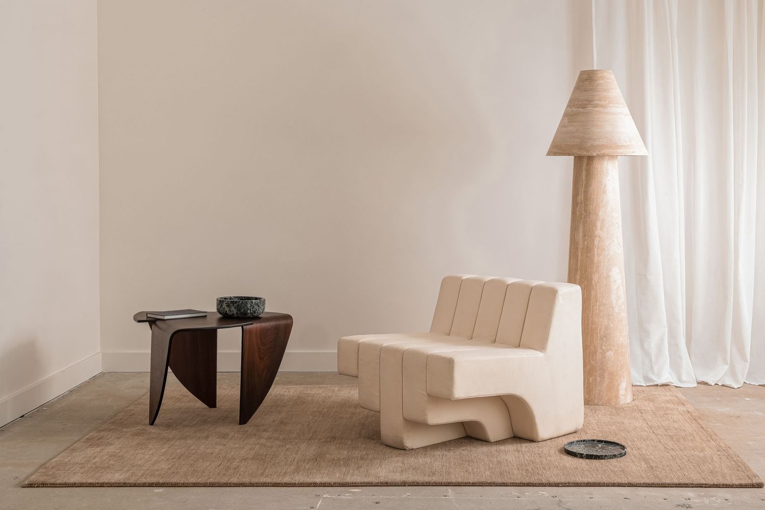 Elegant cream-colored curtains and light wooden furniture create a serene minimalist interior space.