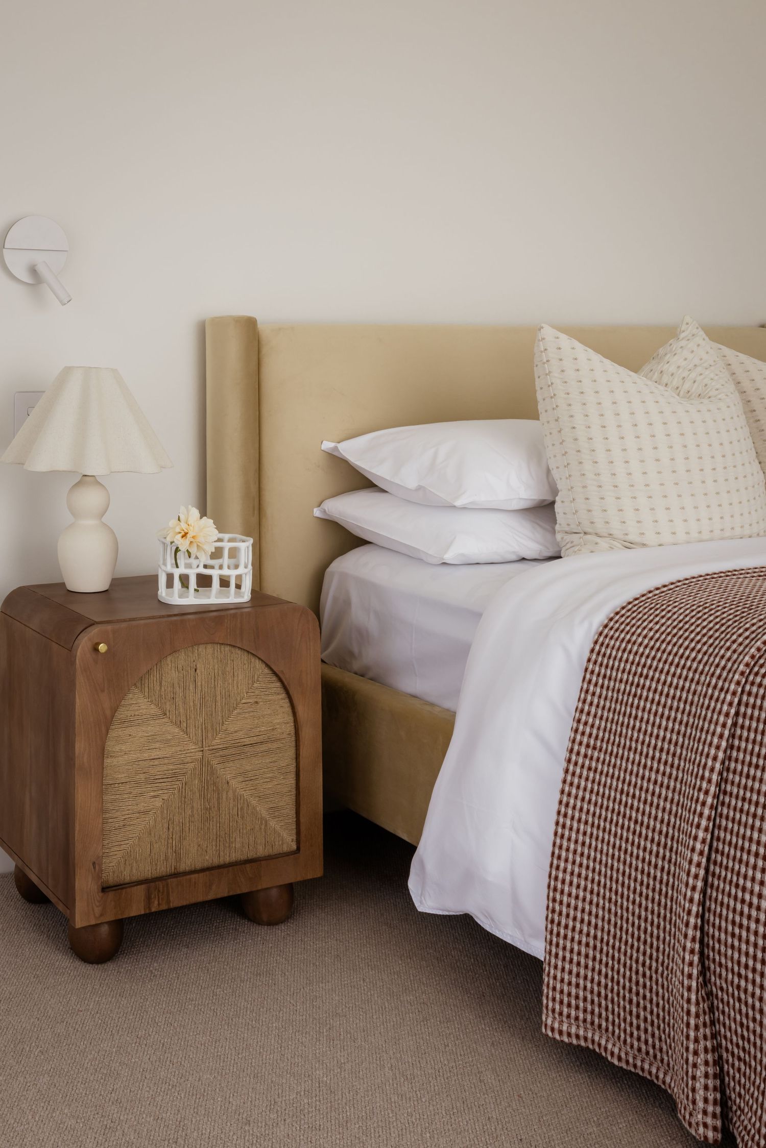 Modern bedroom with wooden furniture featuring brown and white textured bedding and soft neutral tones.