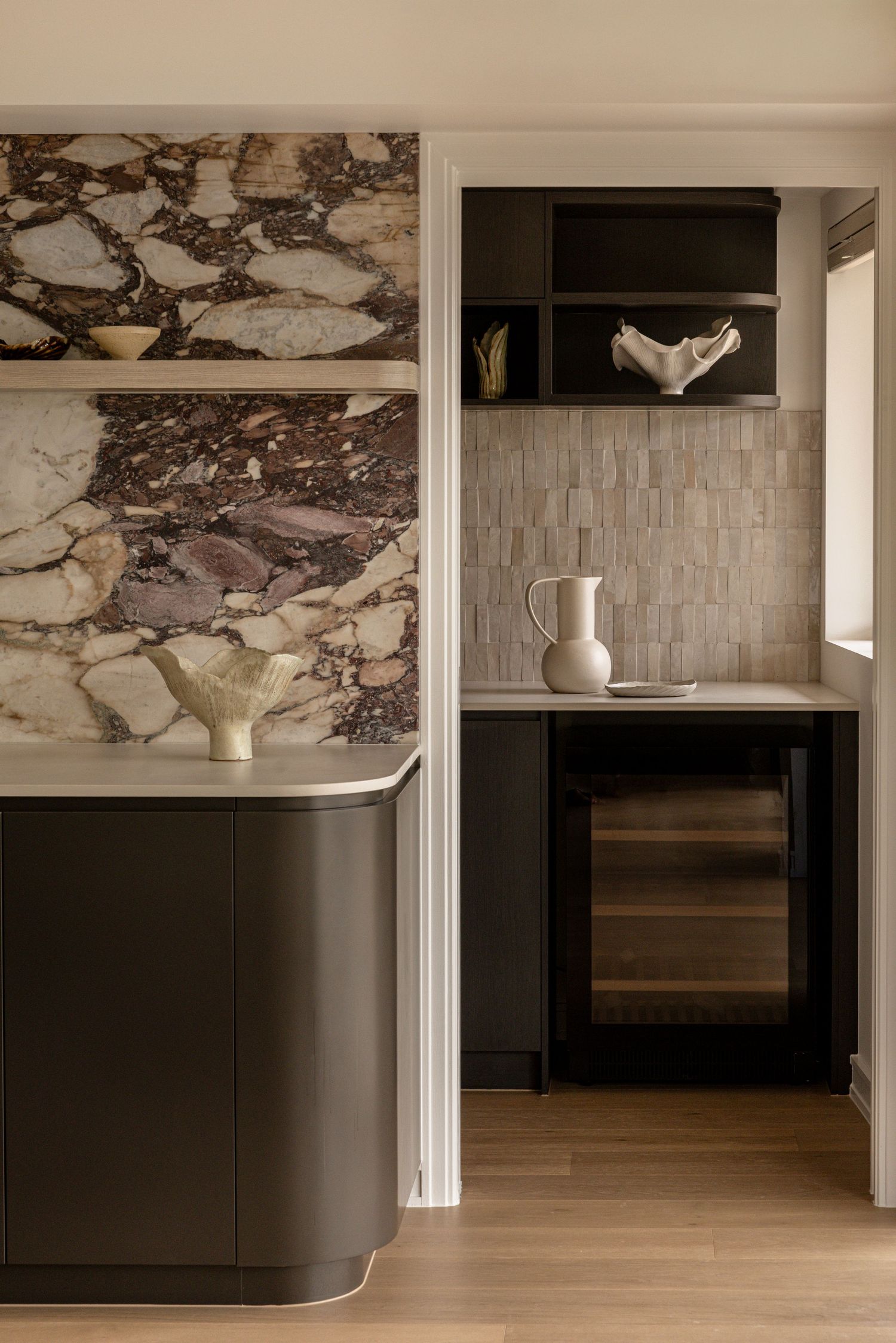Modern kitchen with marble backsplash, dark cabinets, and light wood flooring creates elegant contrast. Canberra interior Photographer