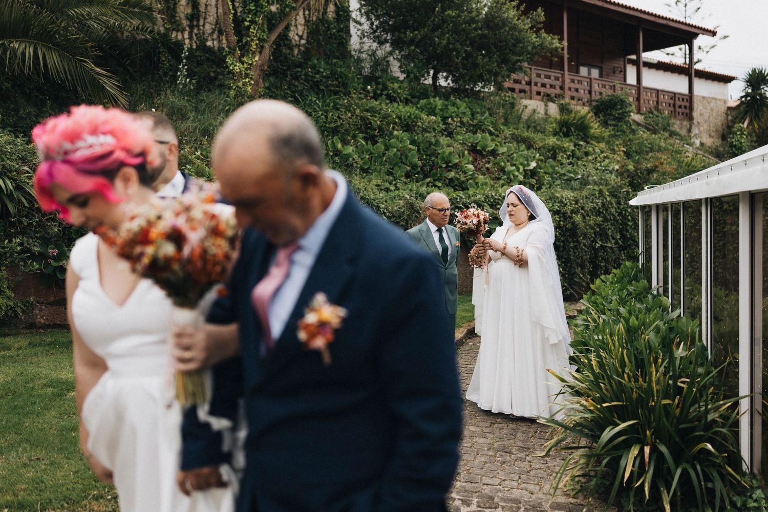 Elegant outdoor wedding ceremony surrounded by lush greenery and natural stone walls.
