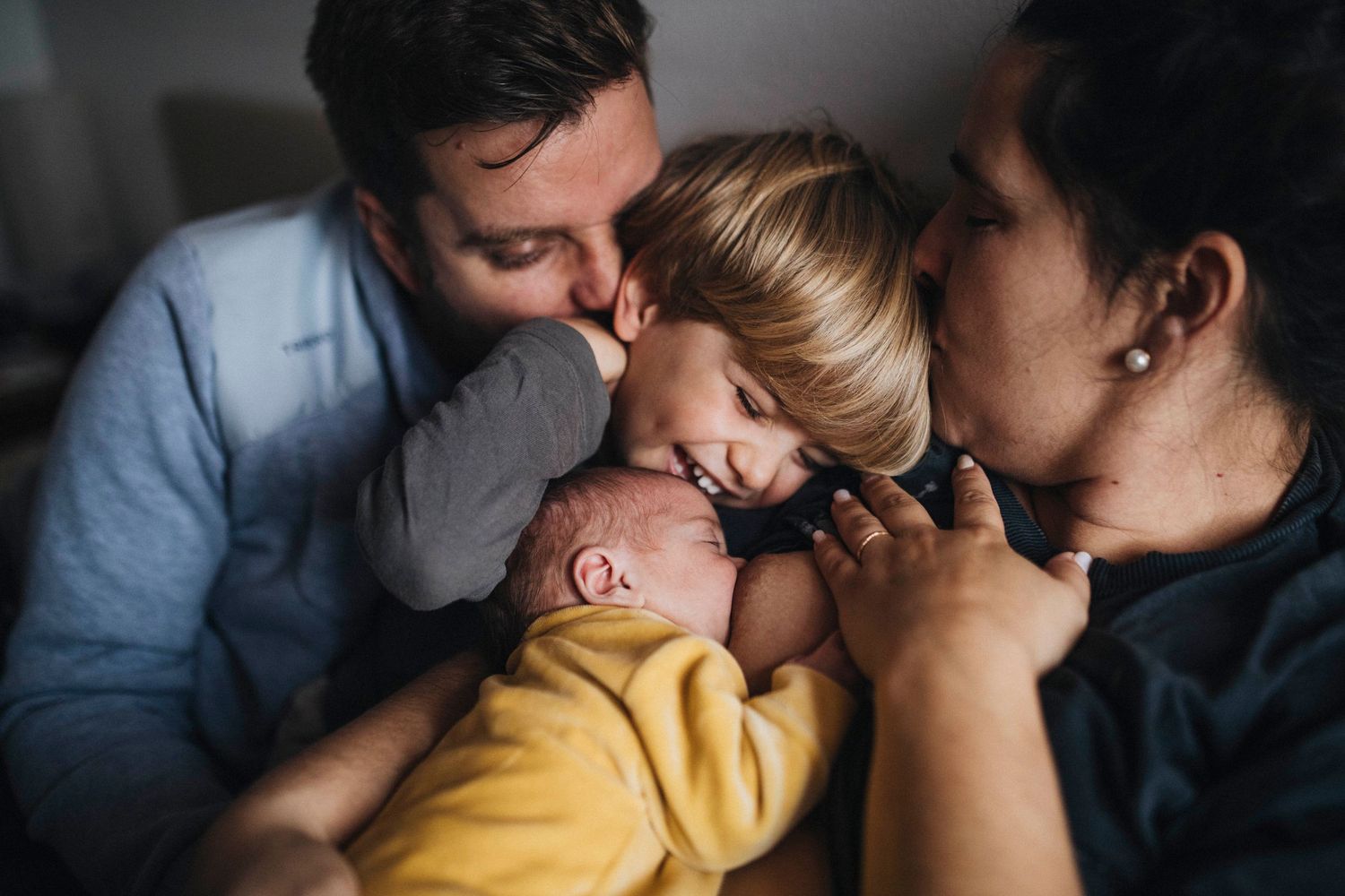 Intimate family moments captured in a series of dark moody photographs showing affection and connection.