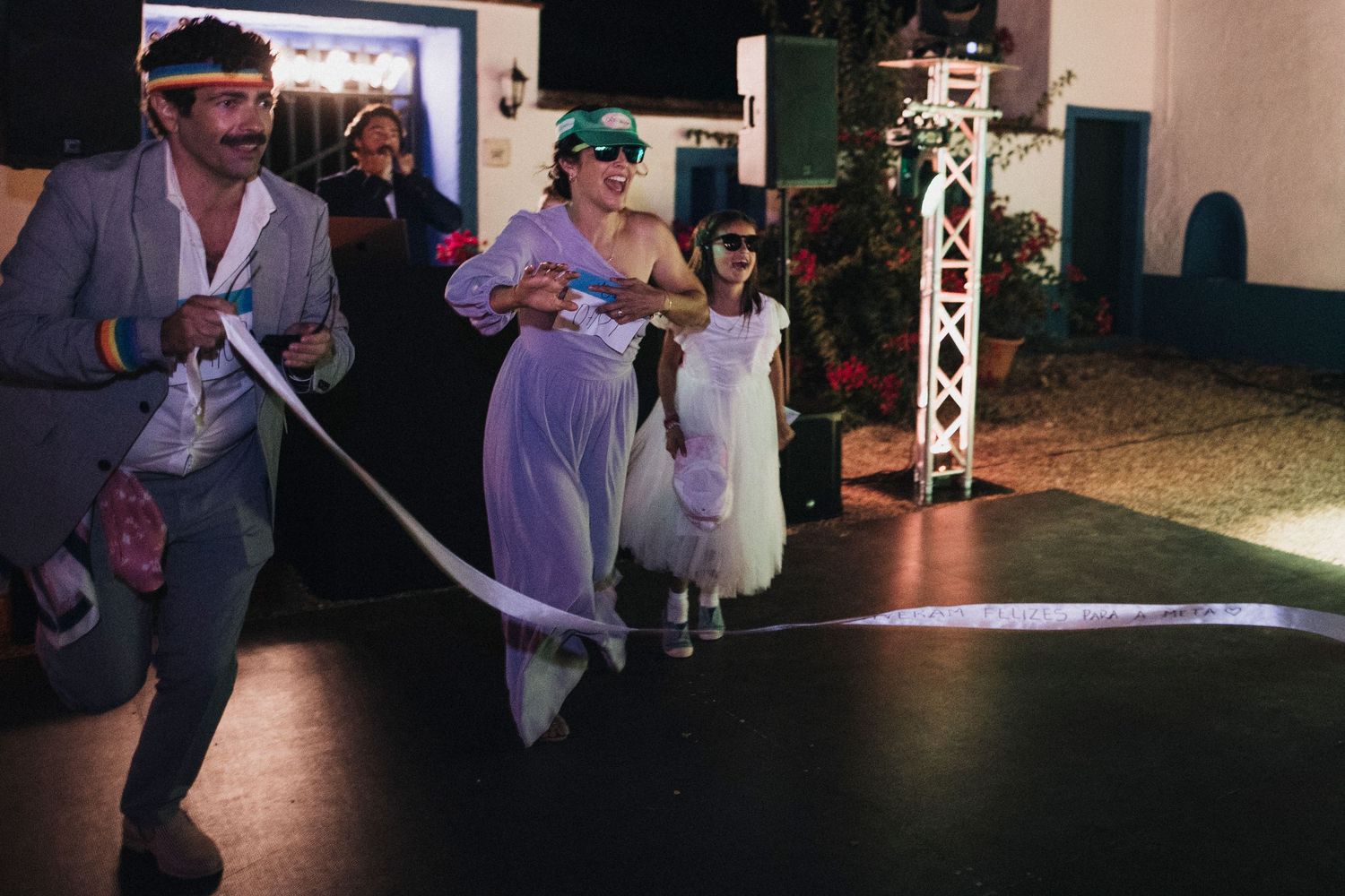 Wedding party members participate in playful party games during evening reception.