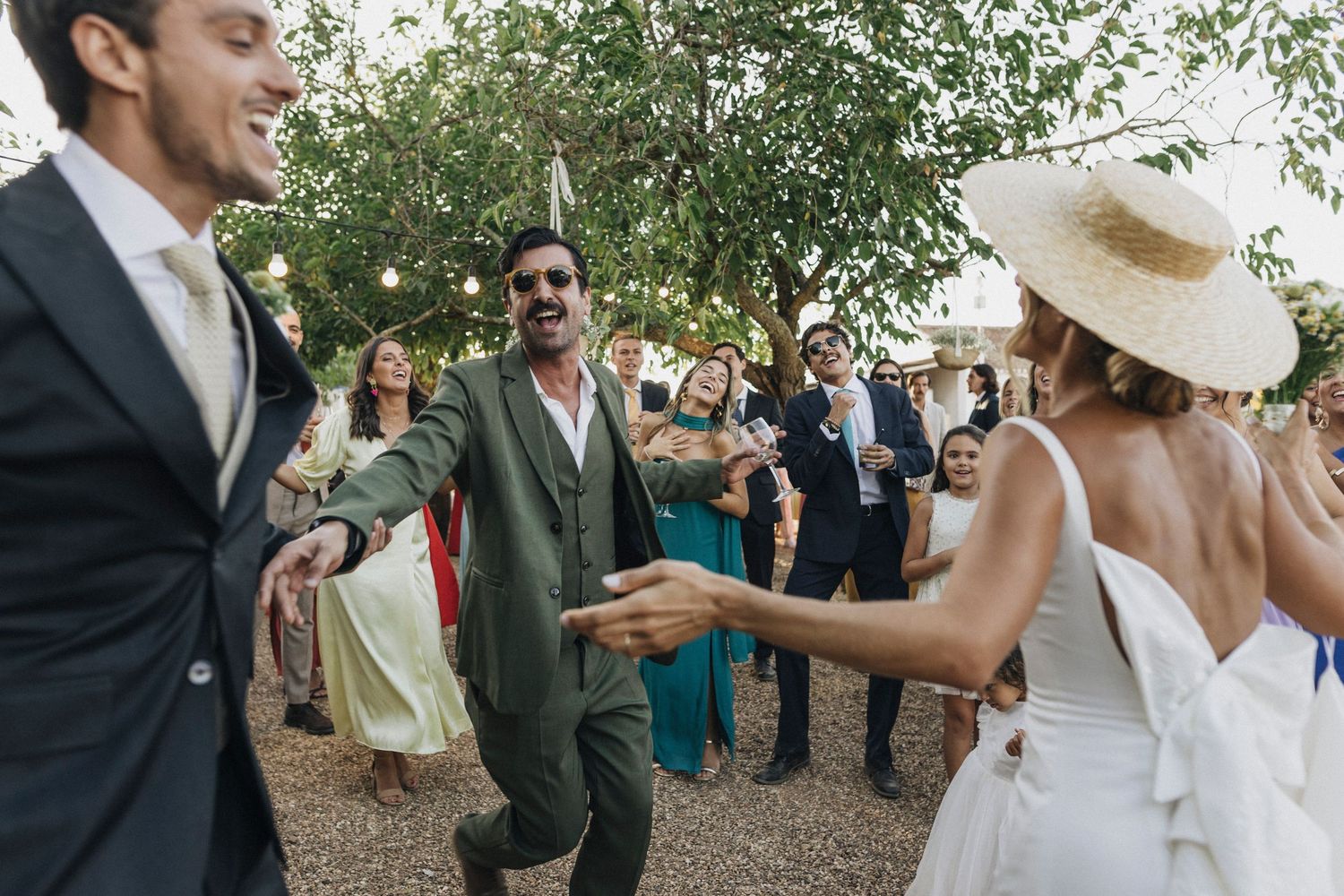 Wedding celebration with guests gathered outdoors under natural lighting.