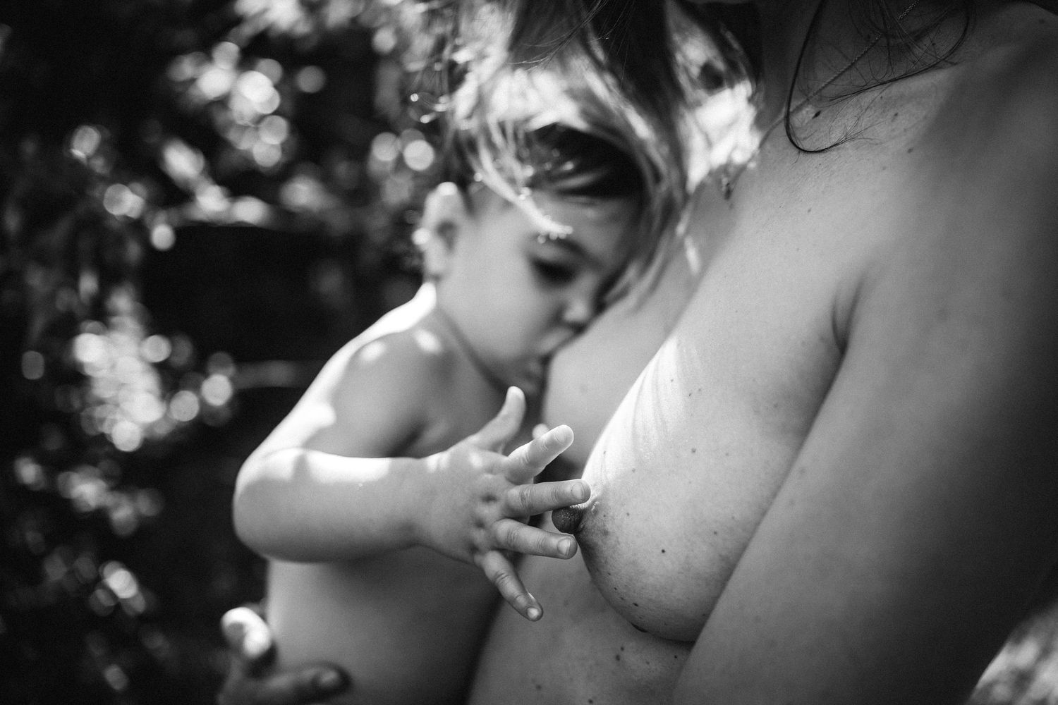 Artistic black and white photograph capturing a gentle moment between mother and baby.