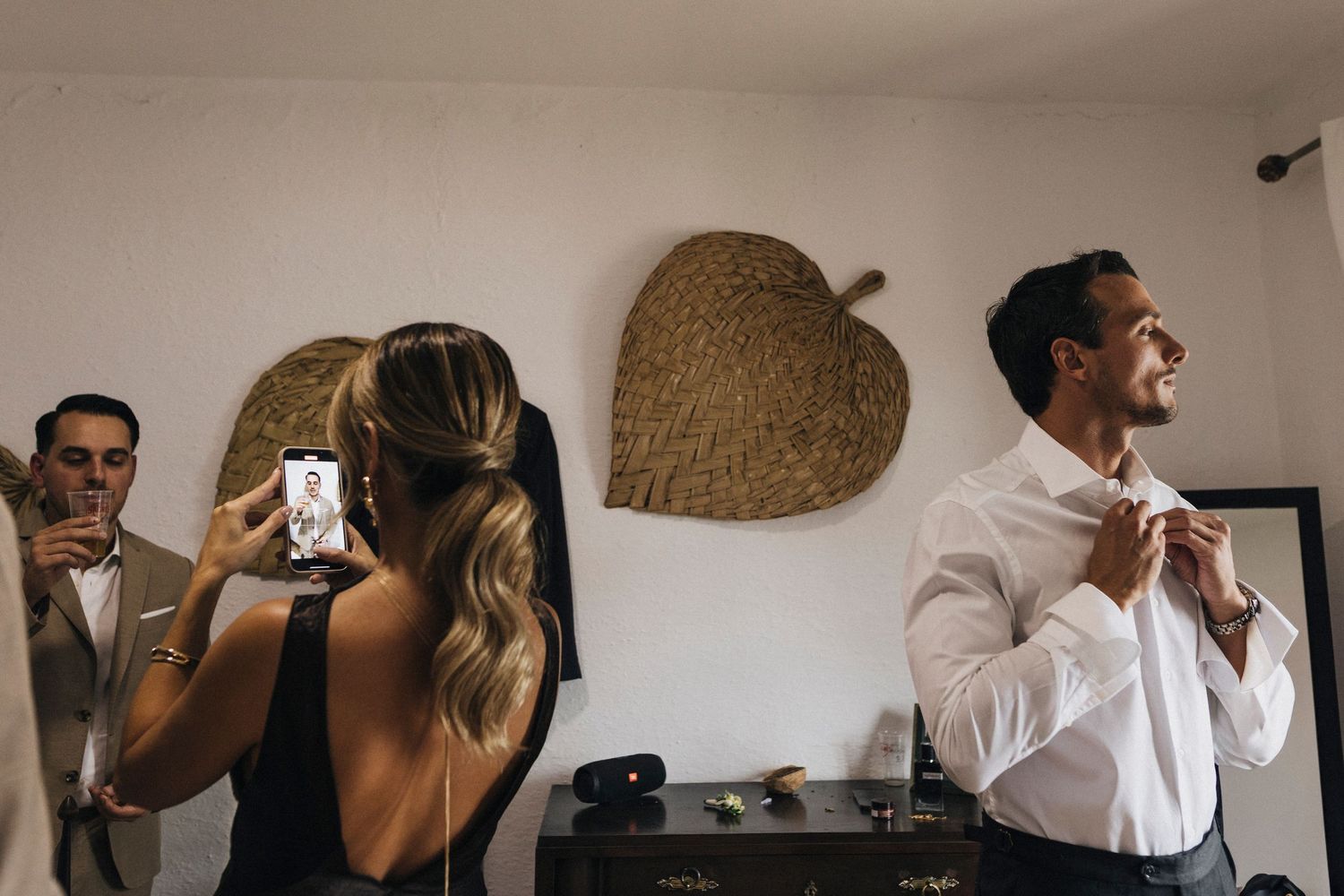 Wedding party getting ready in a minimalist room with natural lighting.