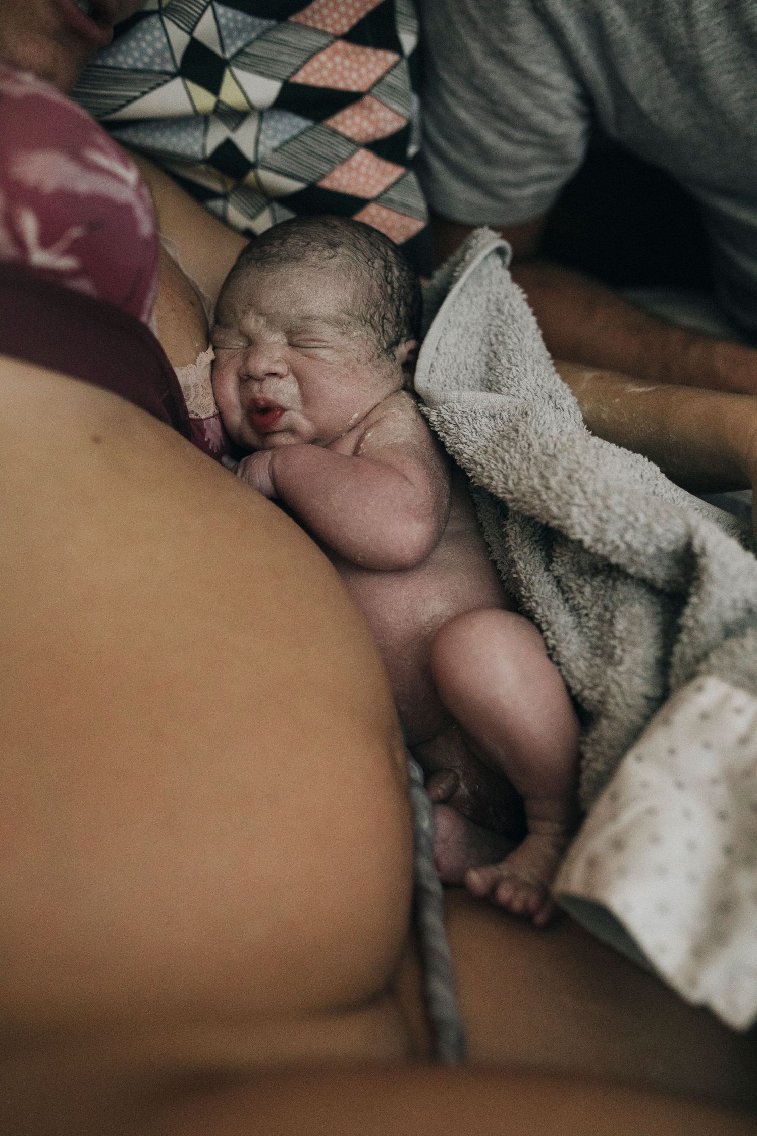 Newborn baby sleeping peacefully while wrapped in a soft blanket.