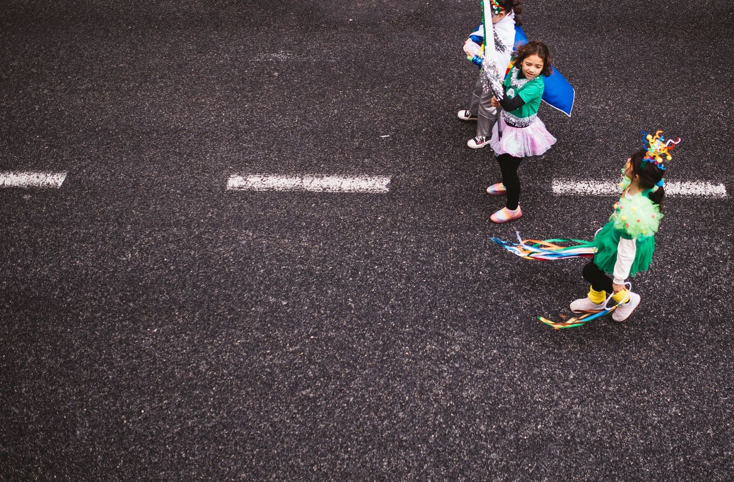 Aerial view of marathon runners on dark asphalt road during a race competition.