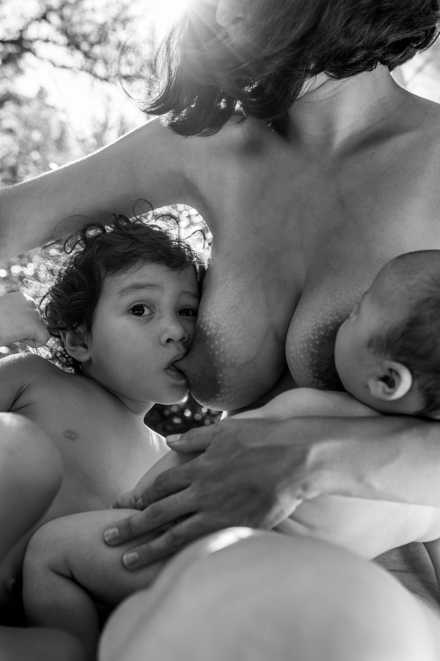 A tender black and white photograph series showing intimate moments of breastfeeding between mother and baby.