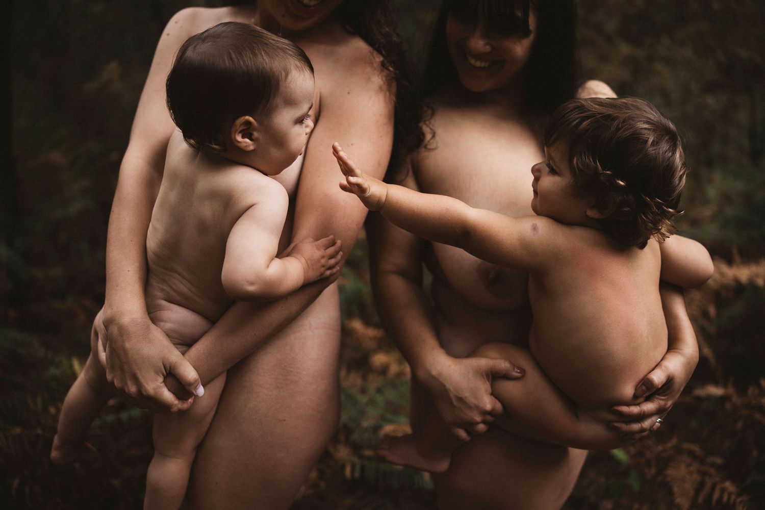 Intimate maternity photography session in a natural outdoor setting.