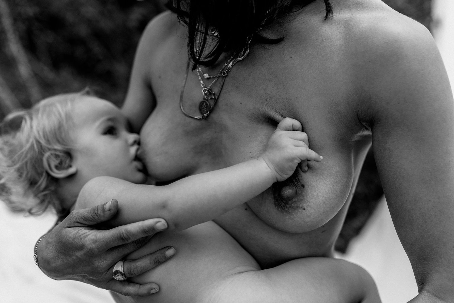 A series of intimate black and white photographs showing tender moments between parent and infant.