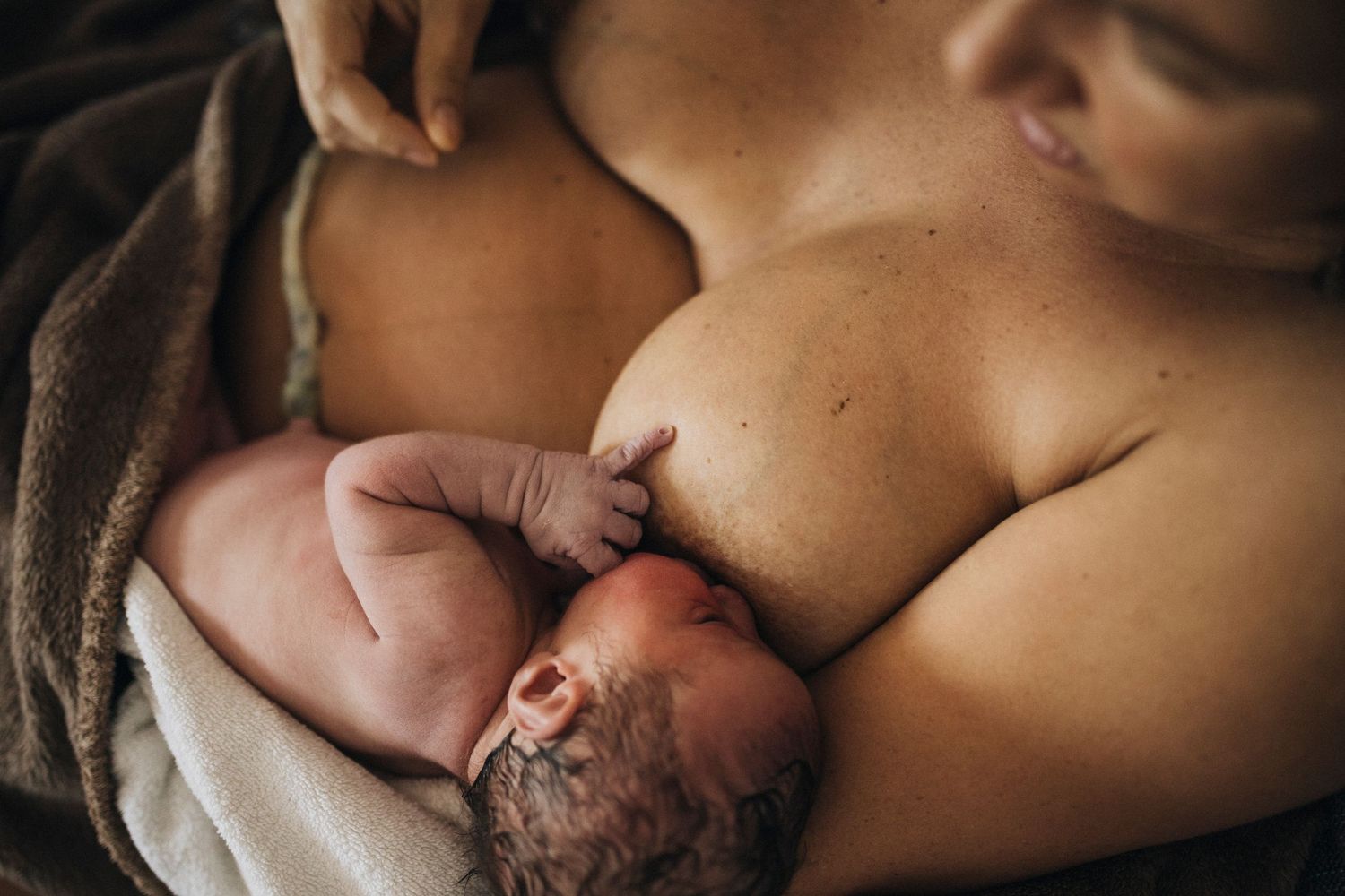 Newborn baby experiencing first moments of skin-to-skin contact after birth.