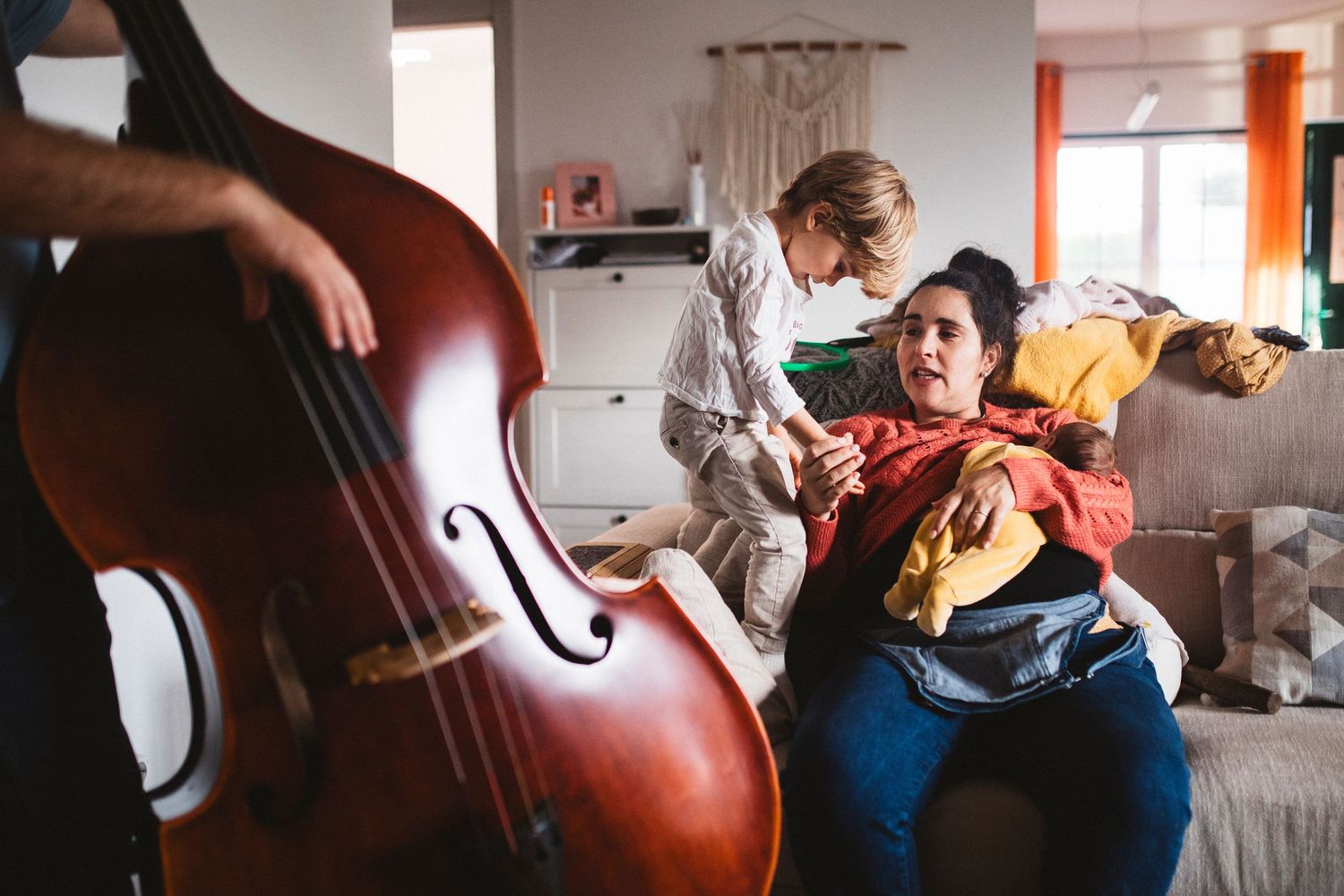 Family spending time together near musical instruments in sunlit living room.