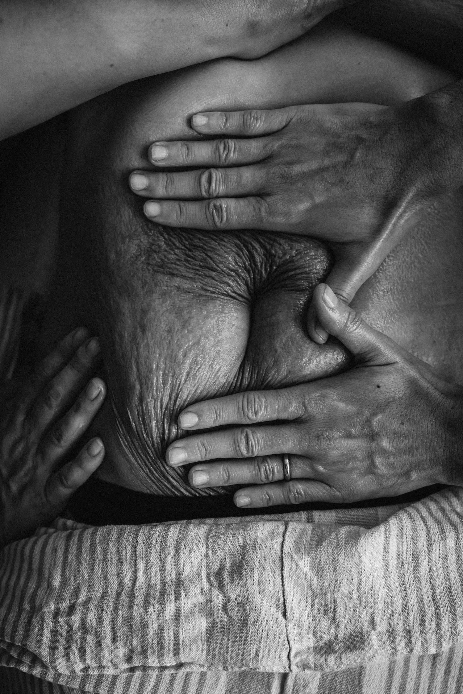 Black and white close-up sequence of hands gently touching and resting on textured fabric in artistic composition.