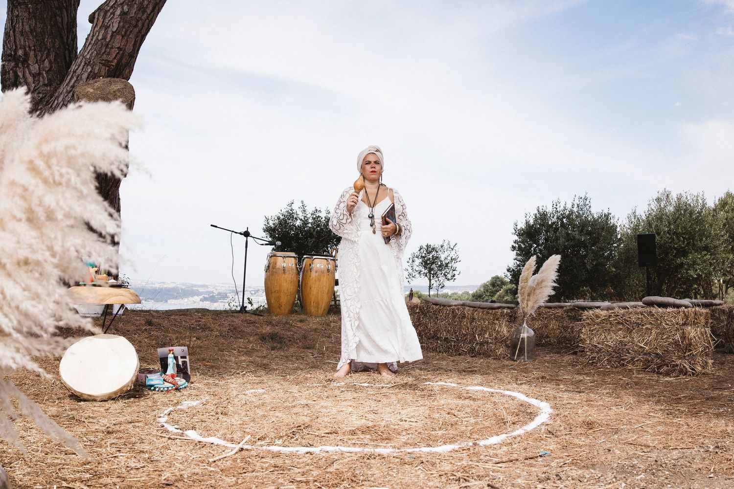 A series of rustic outdoor wedding photos showing white decor and natural elements against an olive grove backdrop.