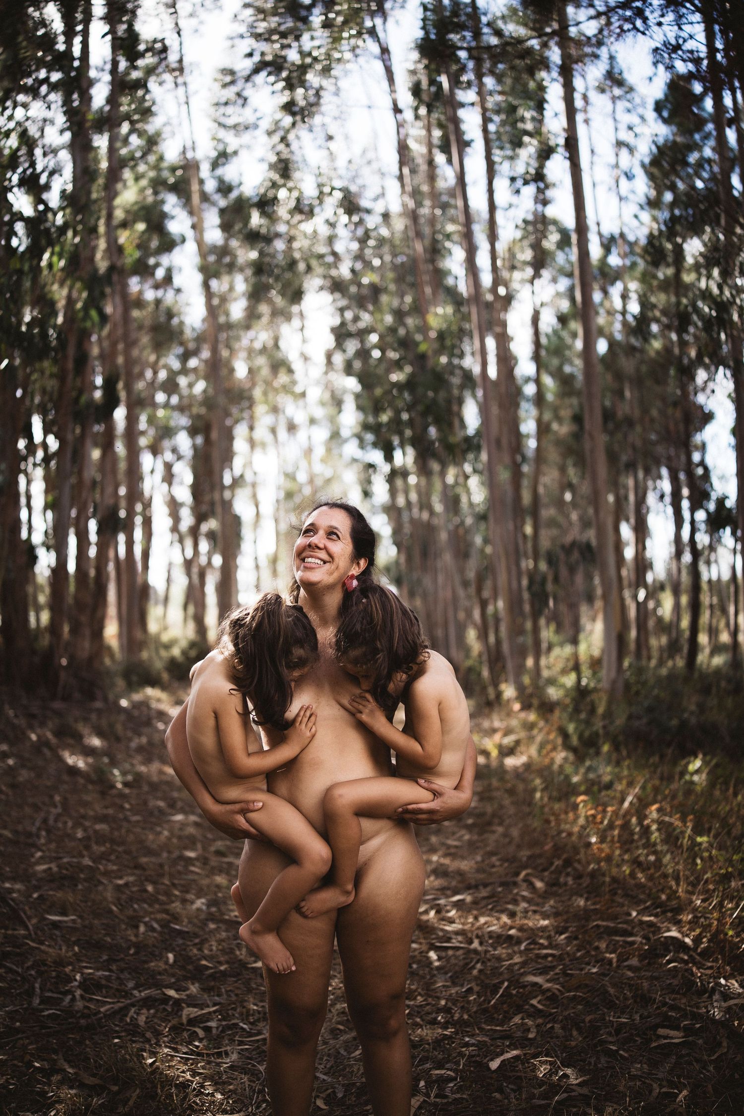 Natural light photography in eucalyptus forest showing joyful connection.
