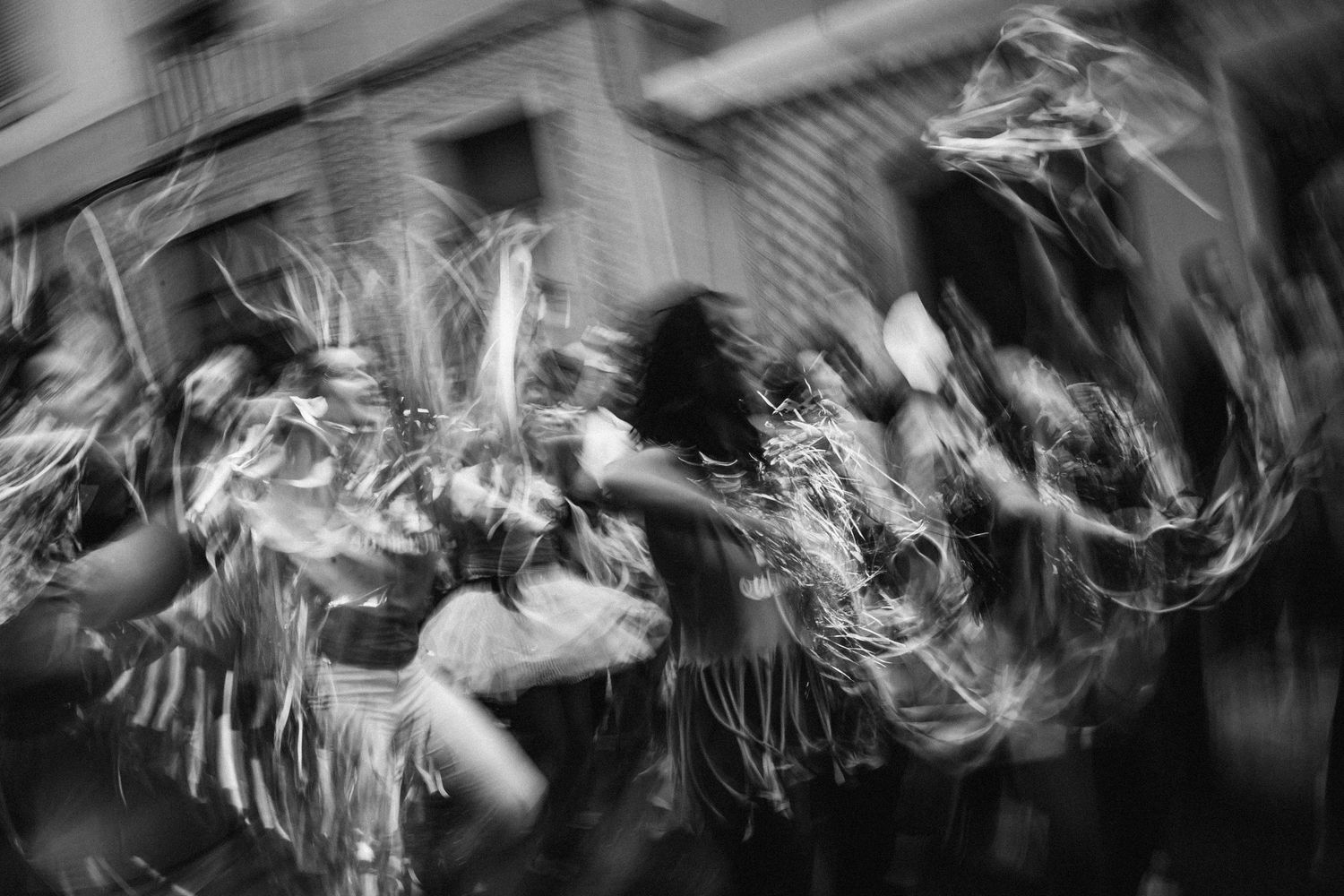 Abstract black and white motion blur photograph showing swirling light trails and dynamic movement patterns.