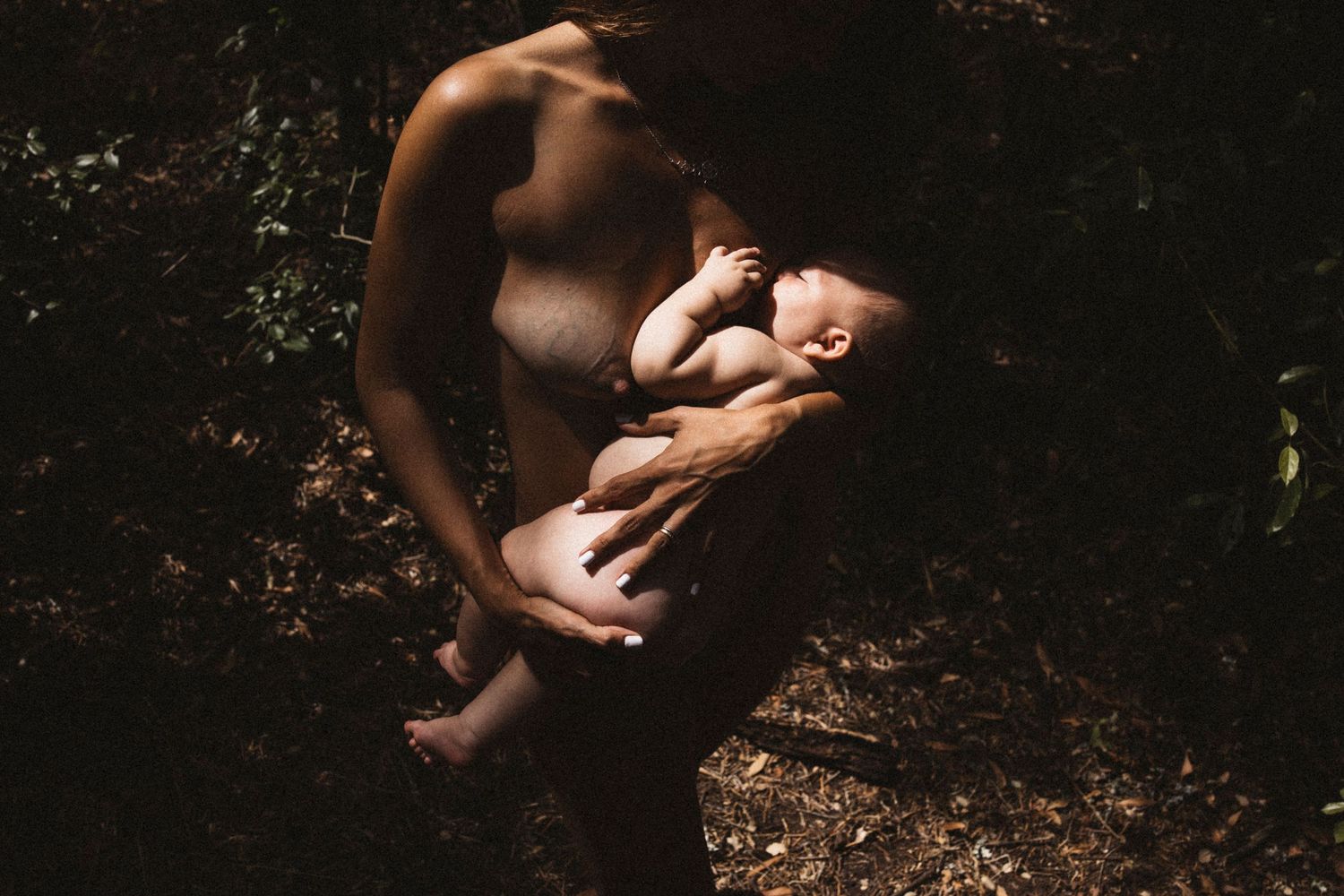 Artistic outdoor photograph showing gentle bonding moment between parent and child.