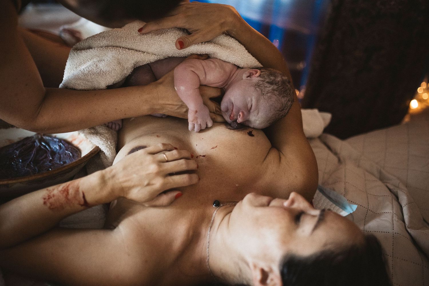 A newborn baby rests on a parent's chest during skin-to-skin contact after birth.