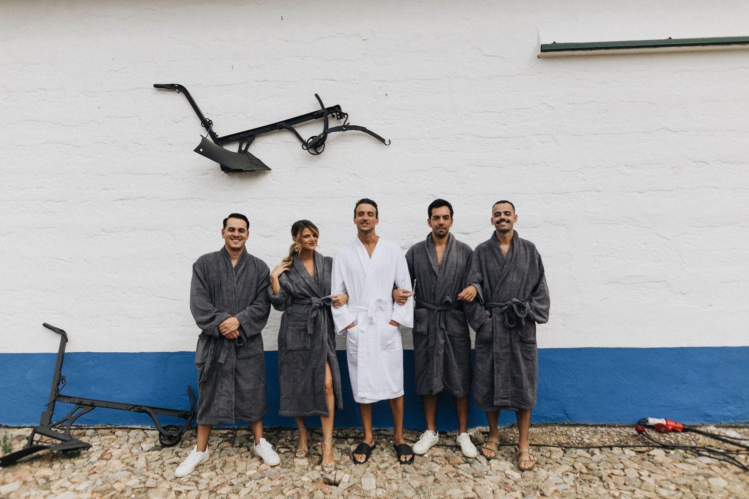 Group of people standing against a white wall in casual attire.