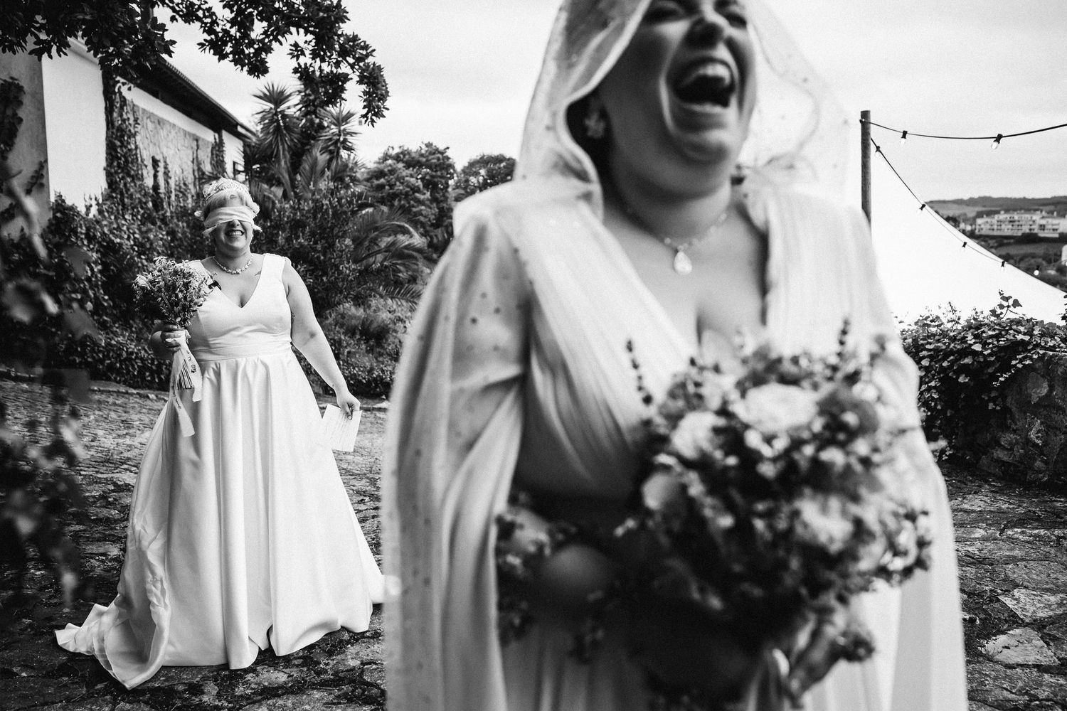 A candid black and white photo captures laughter and celebration at a wedding.