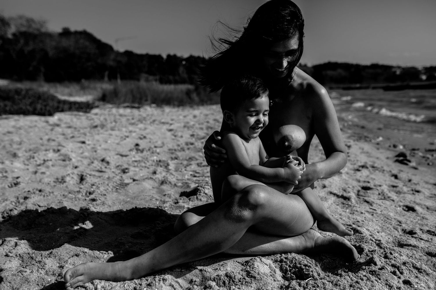 A sequence of black and white photos showing silhouettes of figures relaxing on a sandy beach.