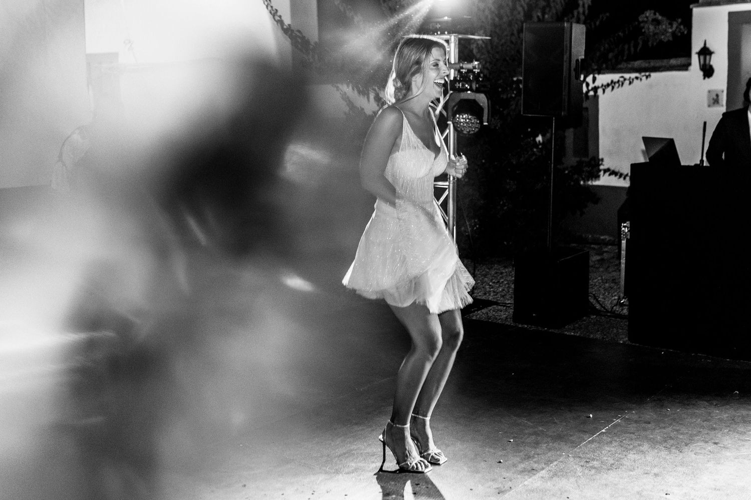 Black and white photo of someone dancing at a wedding reception with motion blur effects.