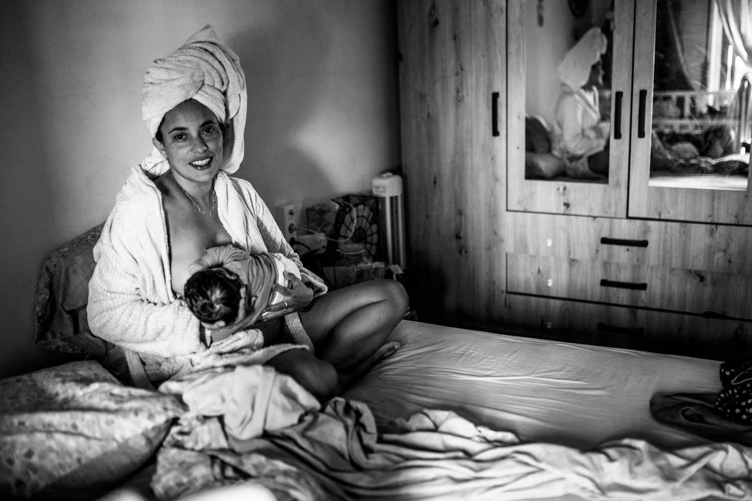 Monochromatic lifestyle photography capturing quiet moments in a sunlit bedroom.
