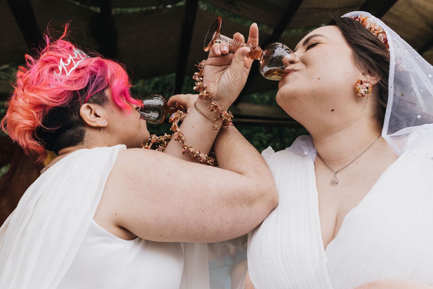 Close-up shot shows vibrant pink hair and wedding attire details during a celebration.