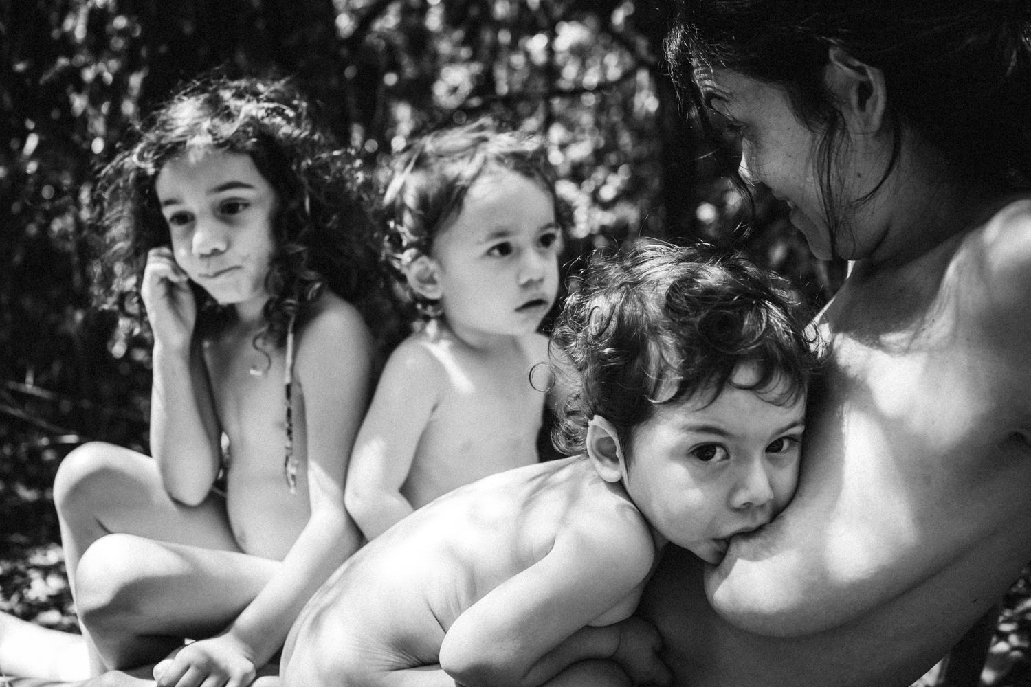 Close-up black and white image showing gentle nursing interaction in natural setting.