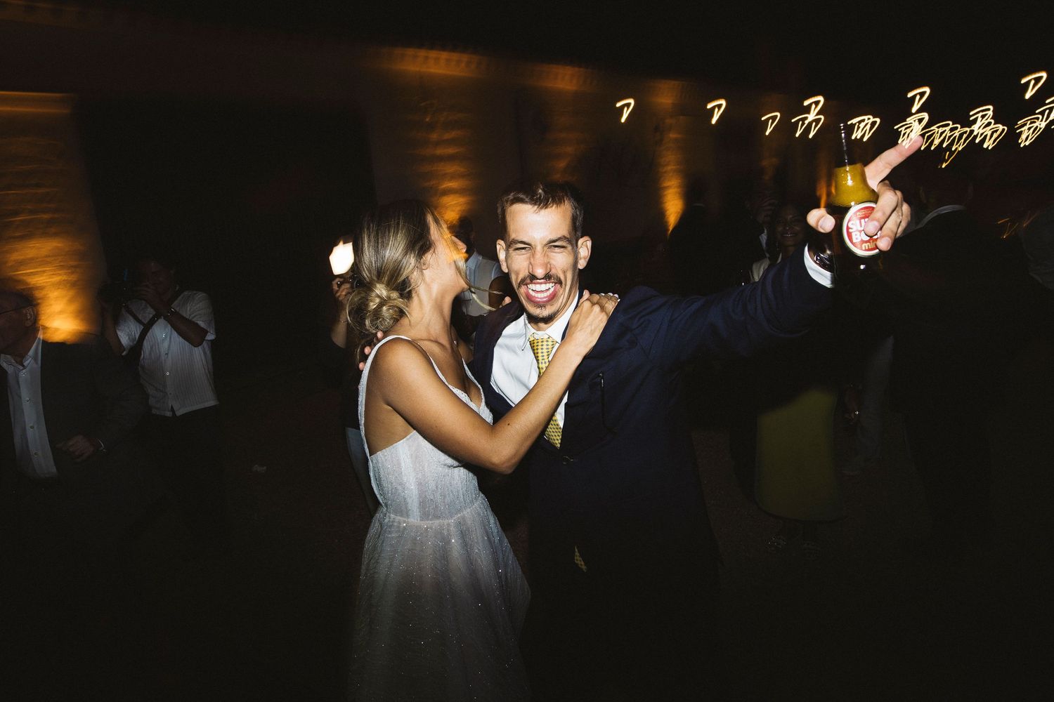 Evening wedding reception with string lights creating a romantic atmosphere on the dance floor.
