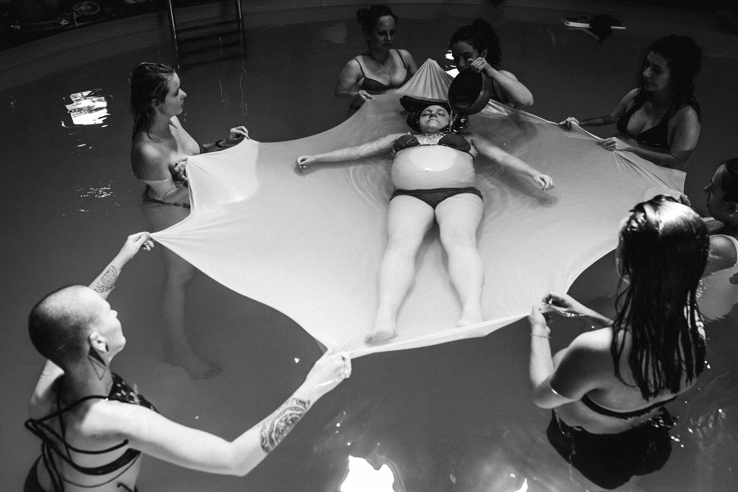 Monochrome images capture dancers performing expressive movements on a light floor.