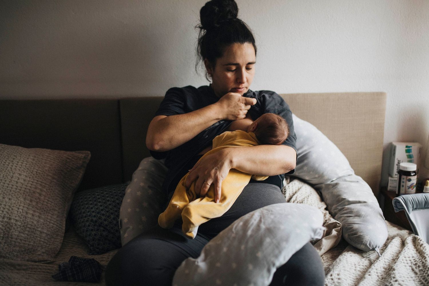 Candid family scene on bed with soft natural window light streaming in.