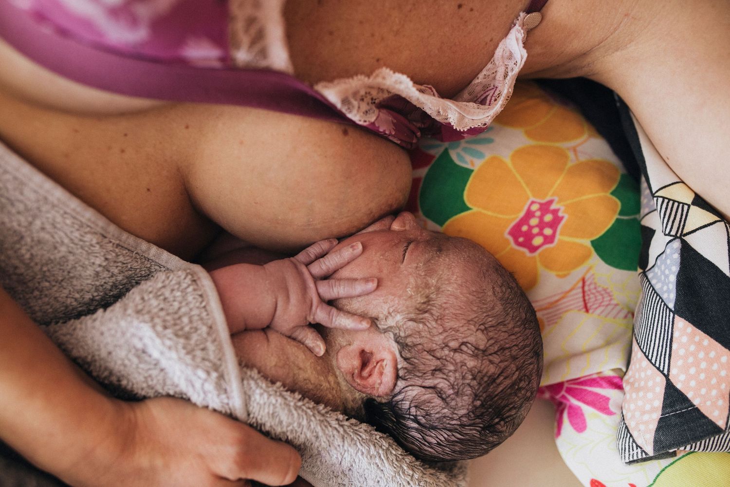 Close-up view of a peaceful birth moment in a dimly lit room.