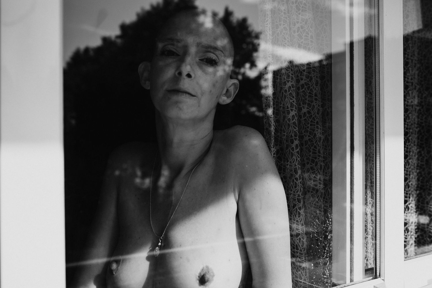 Reflective portrait series through window panes creating multiple fragmented views.