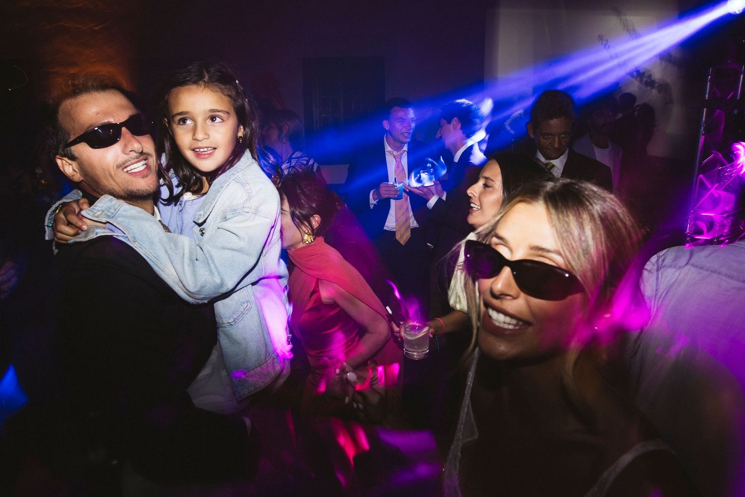 Wedding reception dance party with vibrant blue and purple lighting effects.