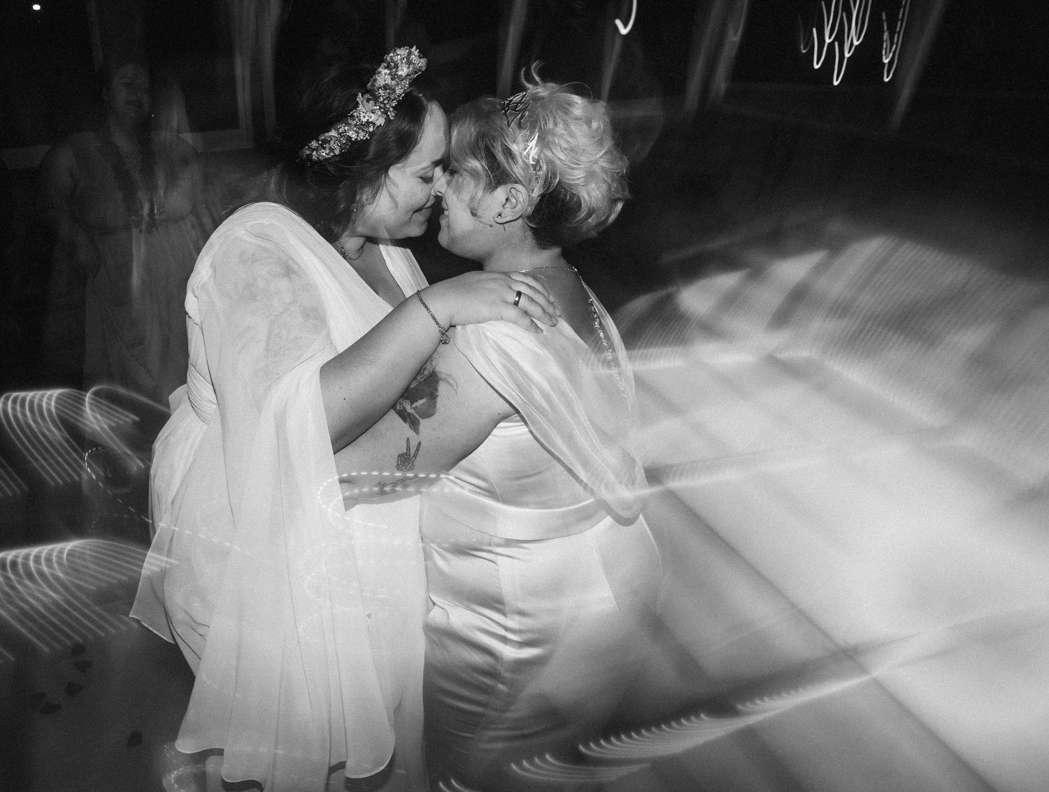 Black and white photo of a romantic first dance between newlyweds surrounded by atmospheric fog on the dance floor.