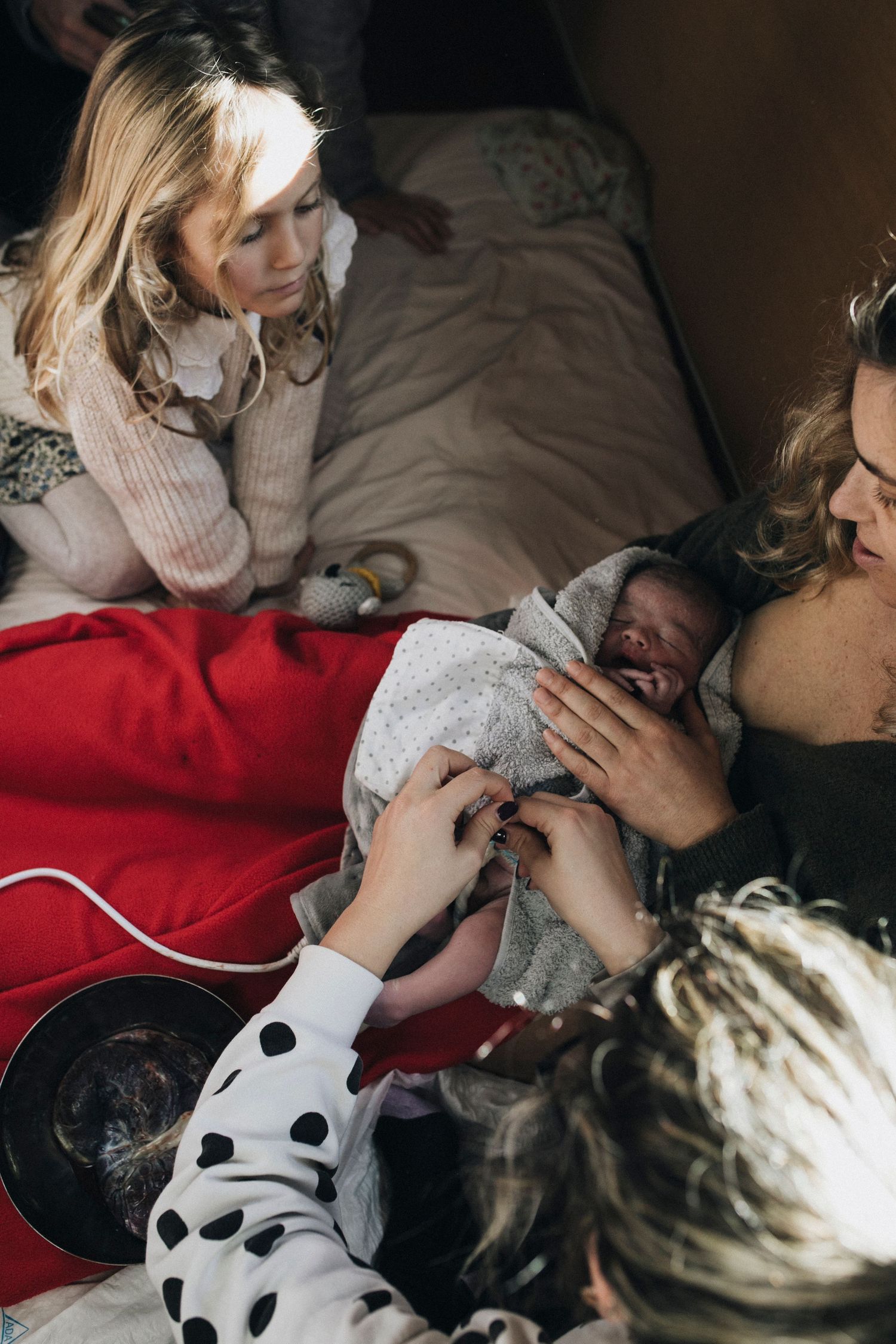 Family members gathered around during an intimate birth moment.