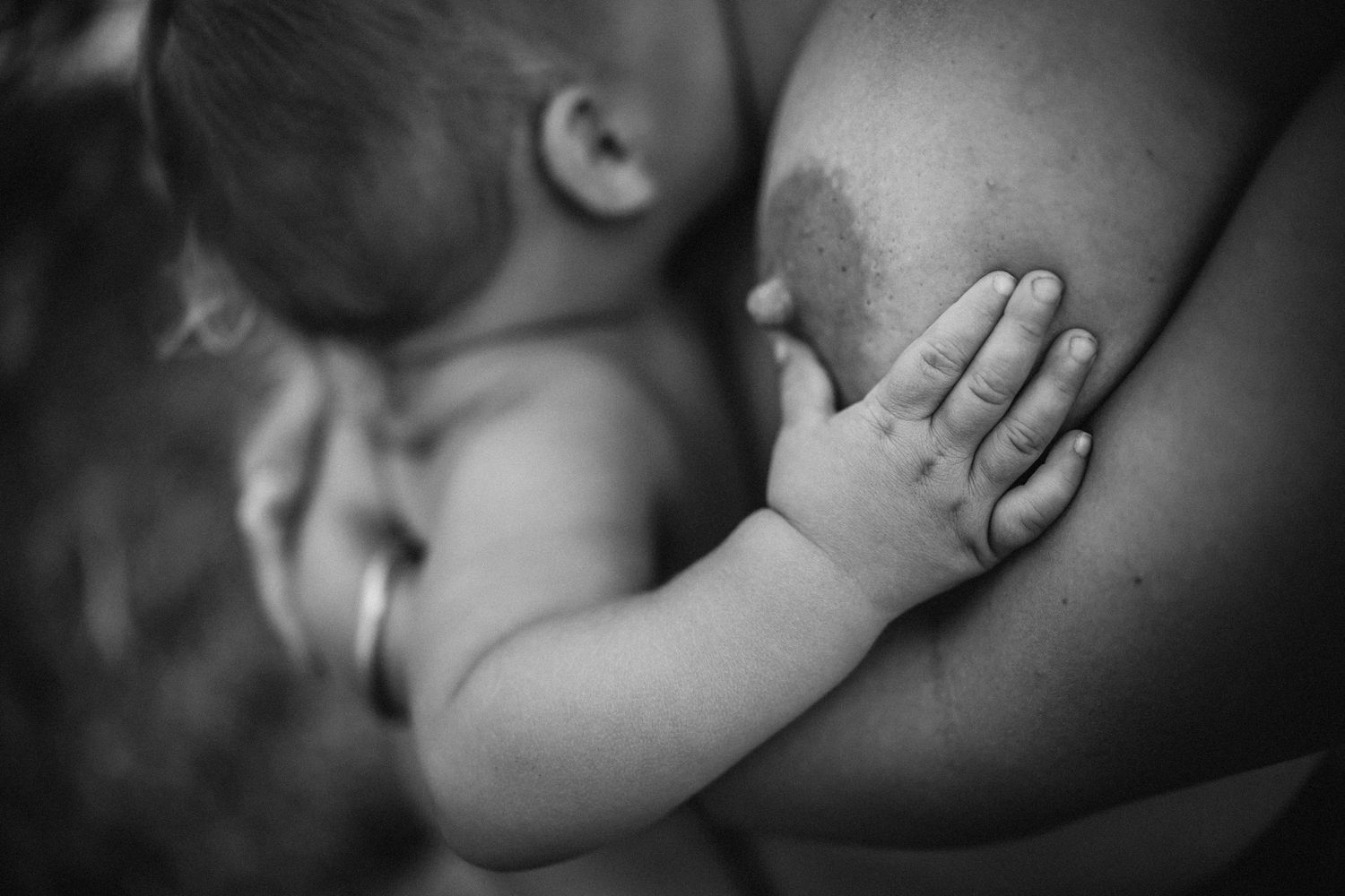 Artistic close-up photograph showing intimate nursing detail in monochrome.