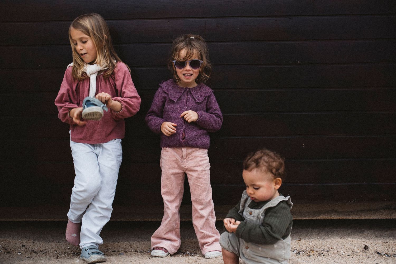 Children playing and walking together against a dark background.