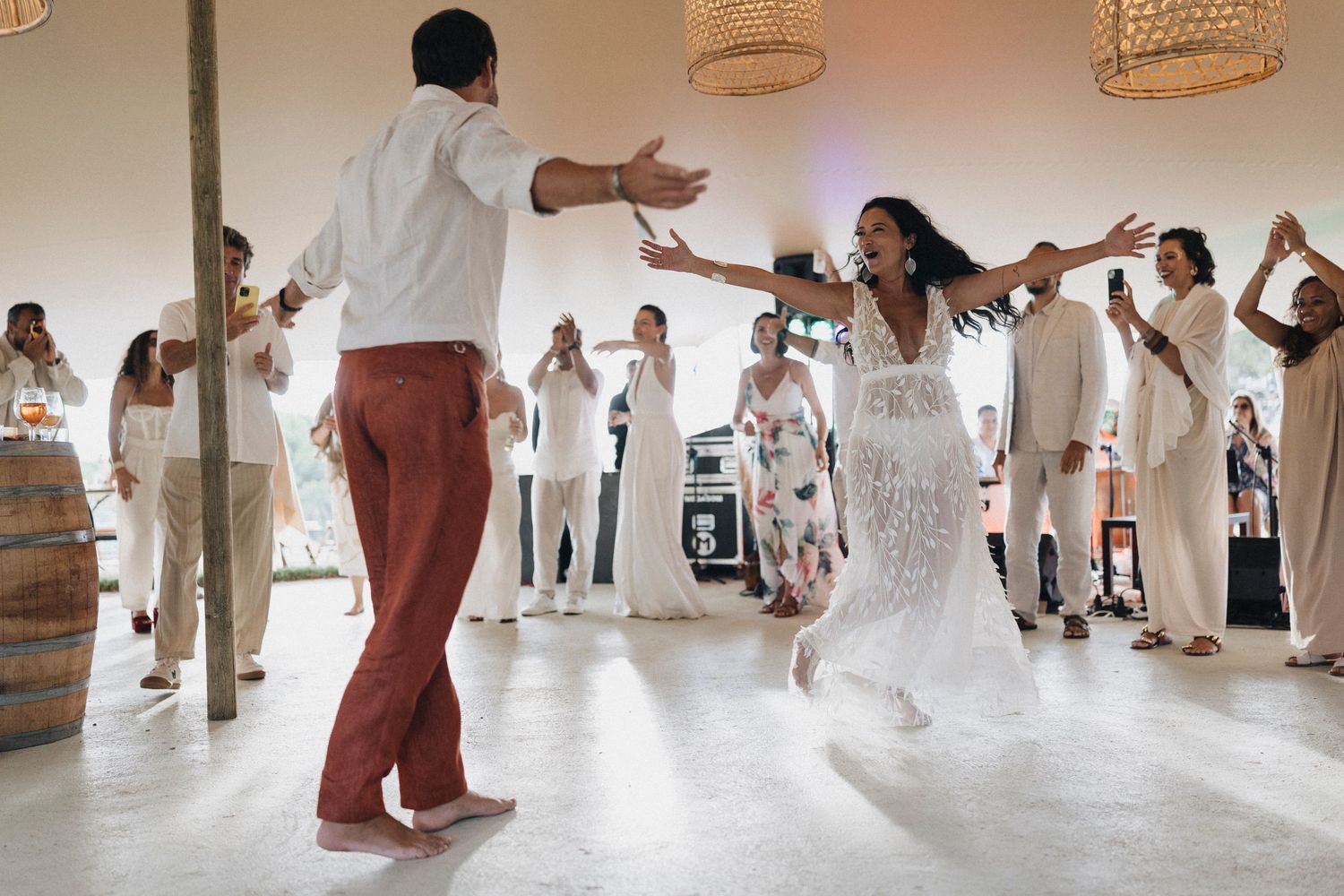 People dancing together in a bright indoor space with woven baskets hanging from the ceiling.